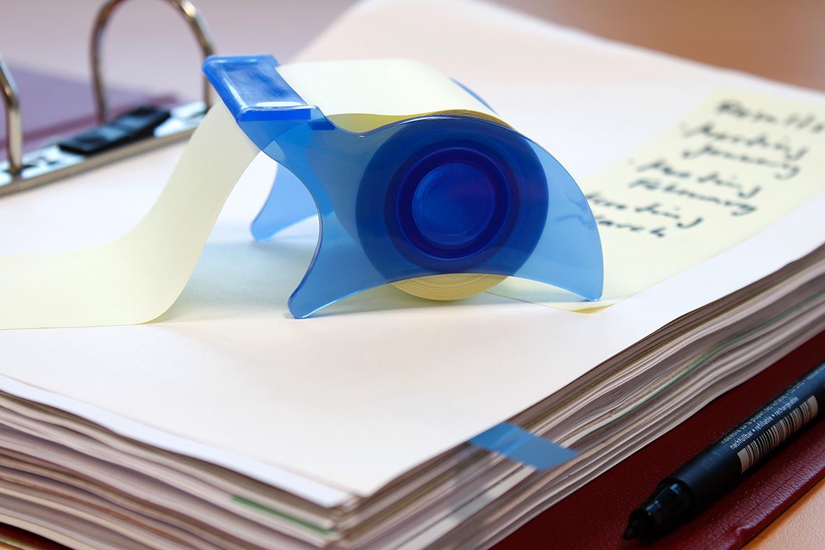 Gul notisblocker på papper med pen och klippare