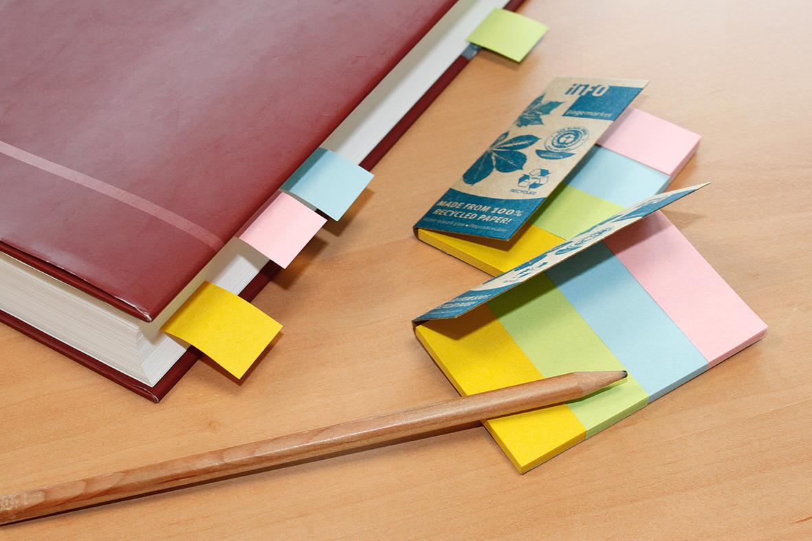 Märkflik med fyra färger och olika storlekar på 20x50mm, placerad på ett bord med en penna och anteckningsblock