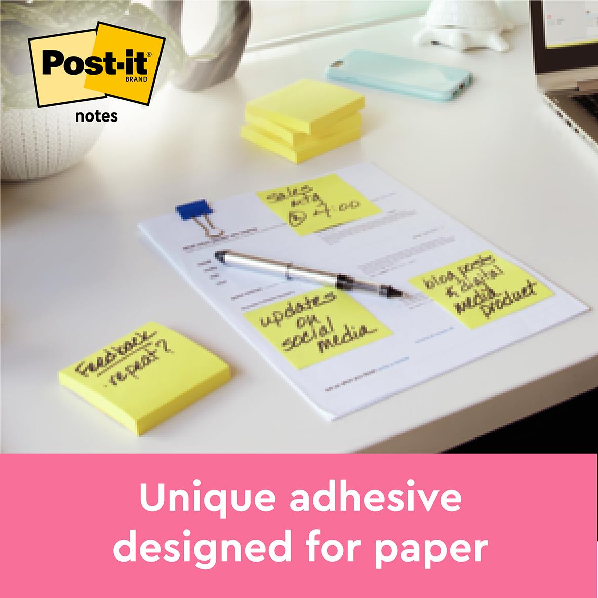 Gula Post-it notisar på skrivbord med papper, penna och andra kontorsmaterial