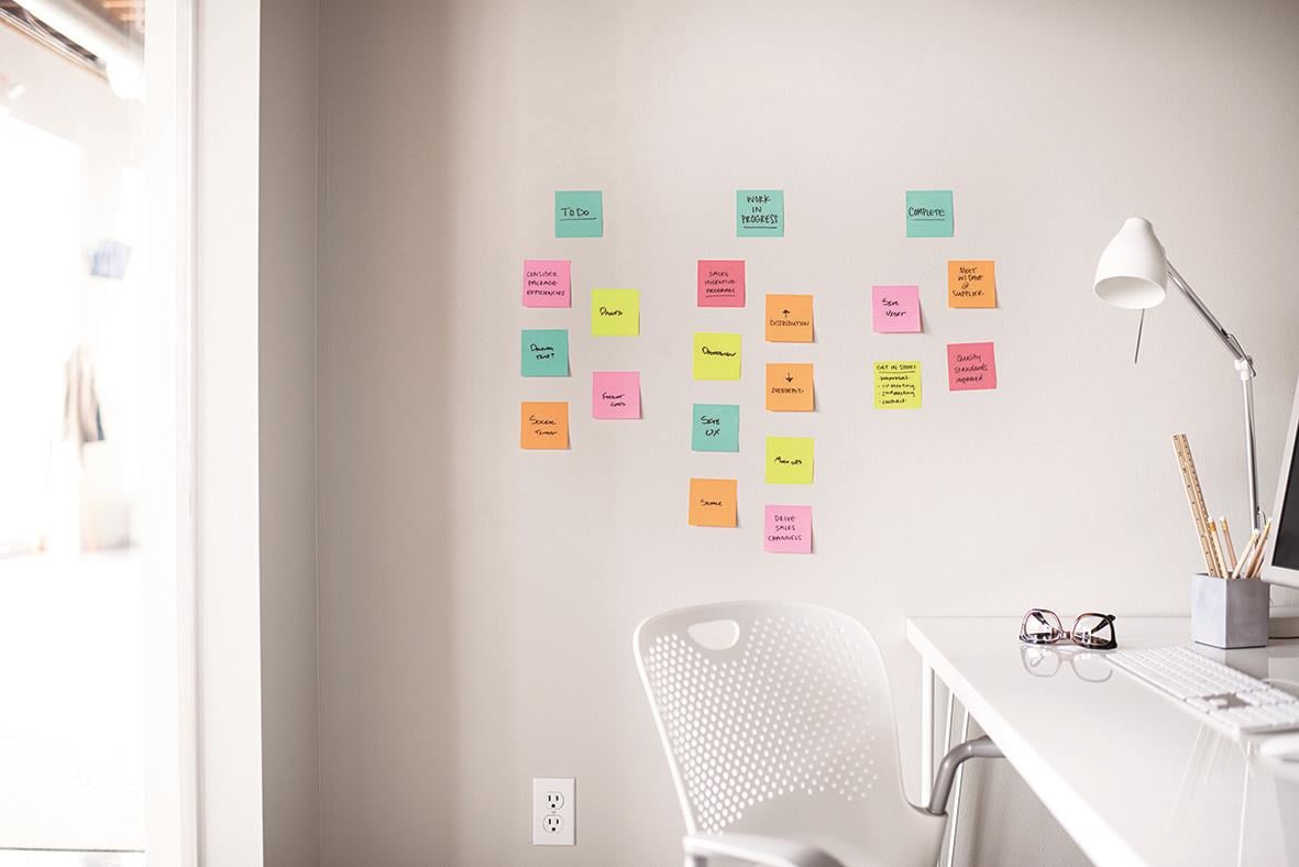 Vägg med färgglada Post-it lappar organiserade i ett mönster i ett hem- eller kontorsrum