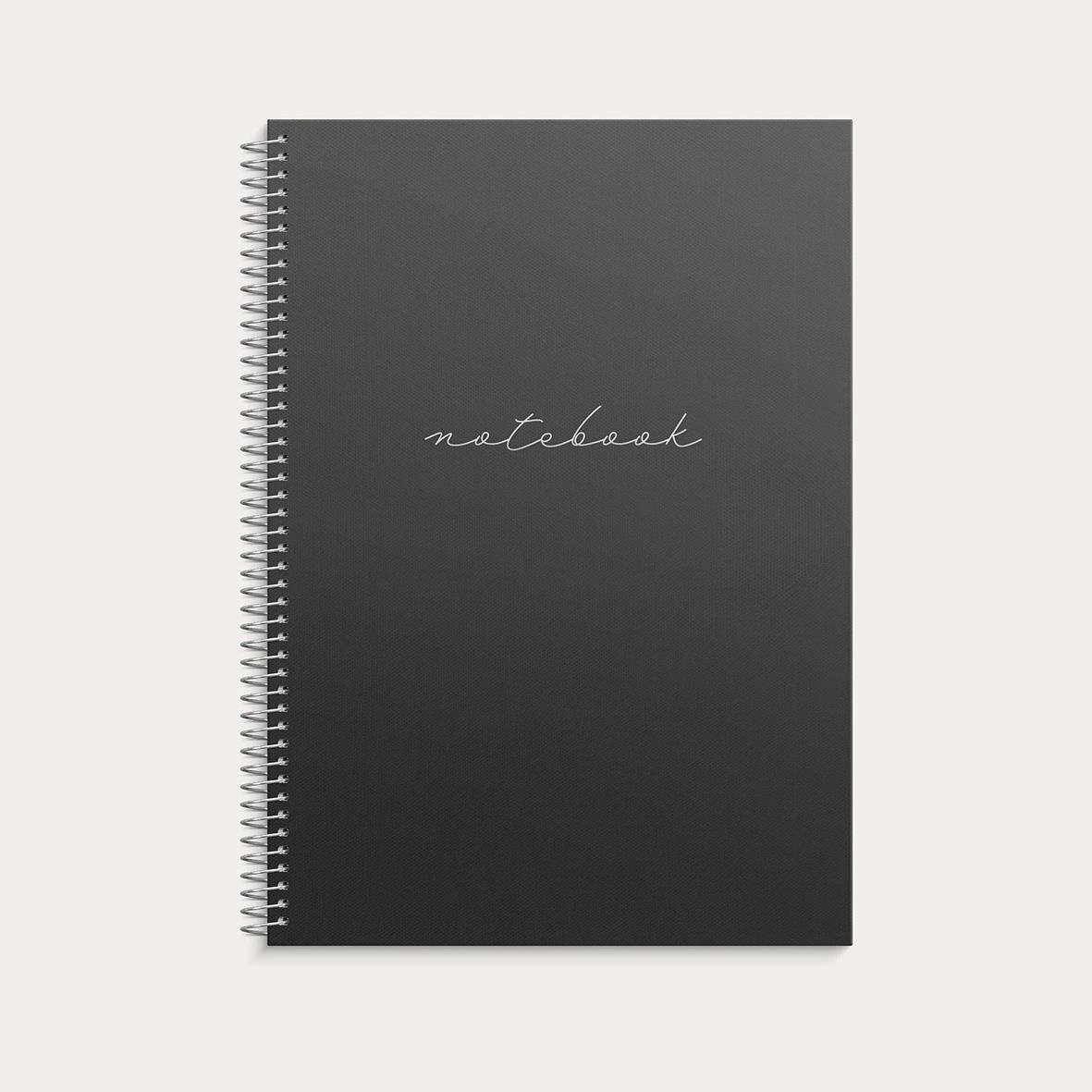 Svart spiralbunden anteckningsbok med linjerad A4-papper och texten notebook på framsidan