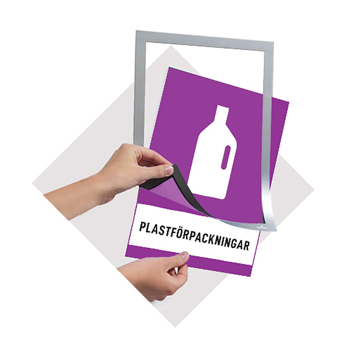 Svart magnetisk Duraframe för A5 med hand som sätter på en plastficka med etiketten plastförpackningar