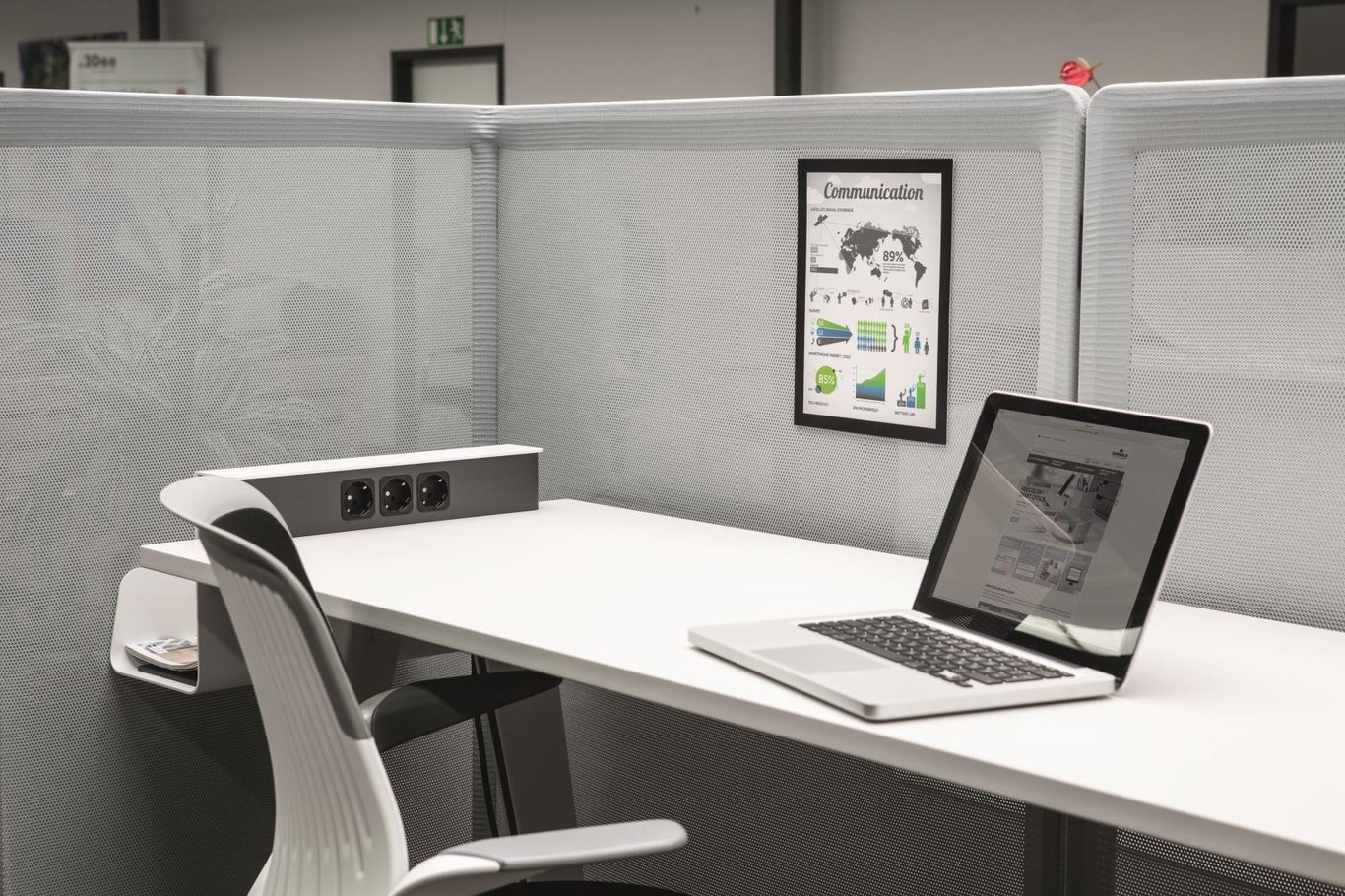 Arbetsplats med svart Duraframe Grip A4, laptop och stol i ett kontorslandskap