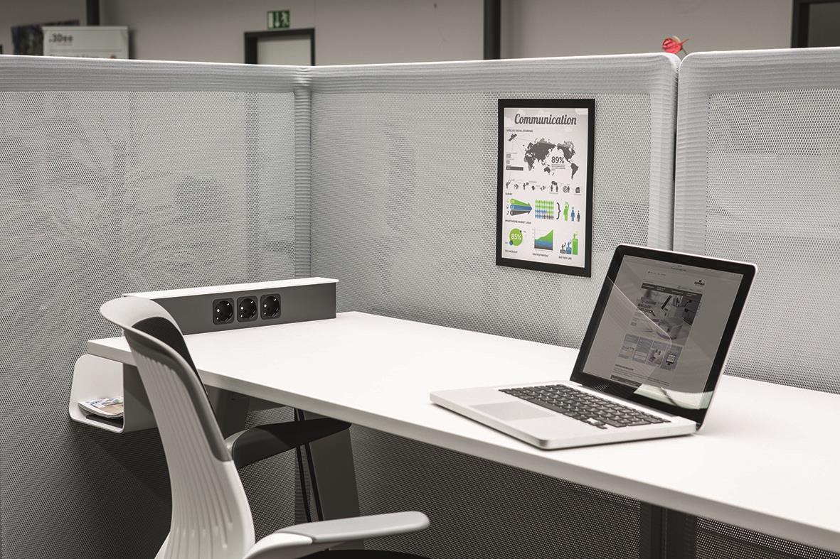 Arbetsplats med svart Duraframe Grip A4, laptop och stol i ett kontorslandskap