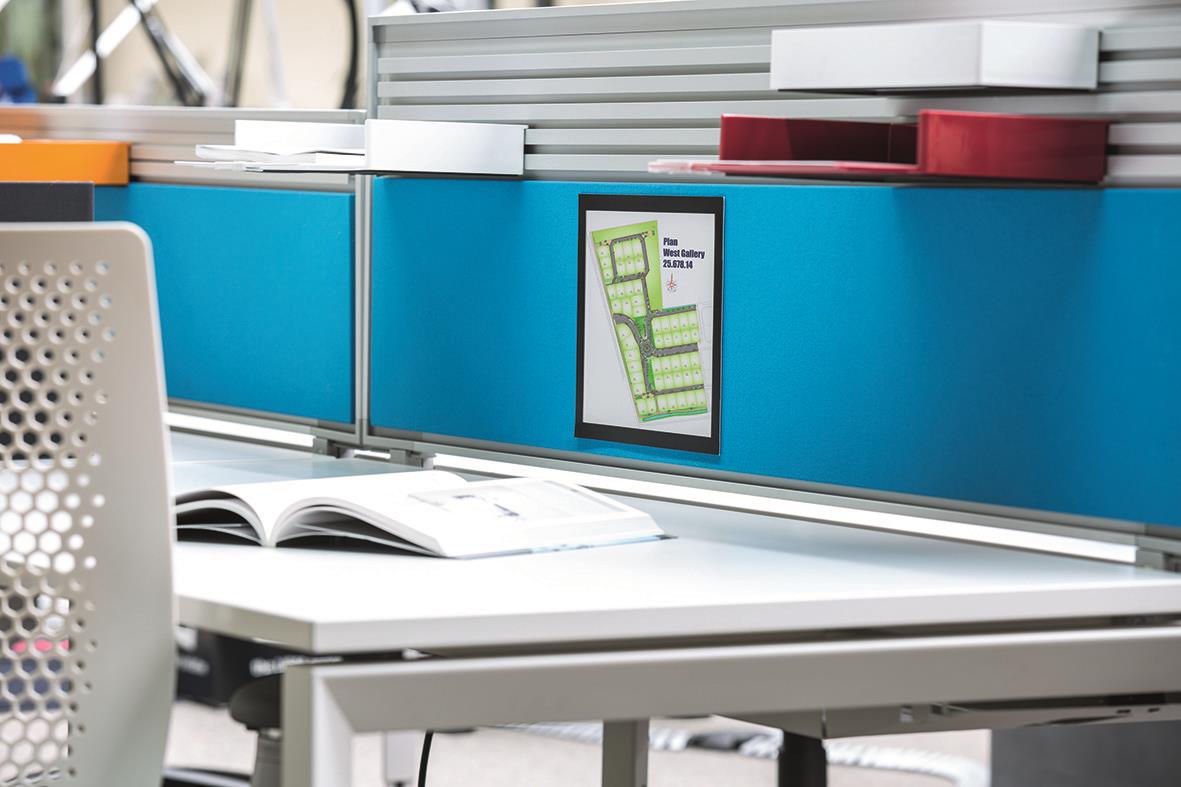 Svart Duraframe Grip A4 på kontorsvägg med dokument och hyllor