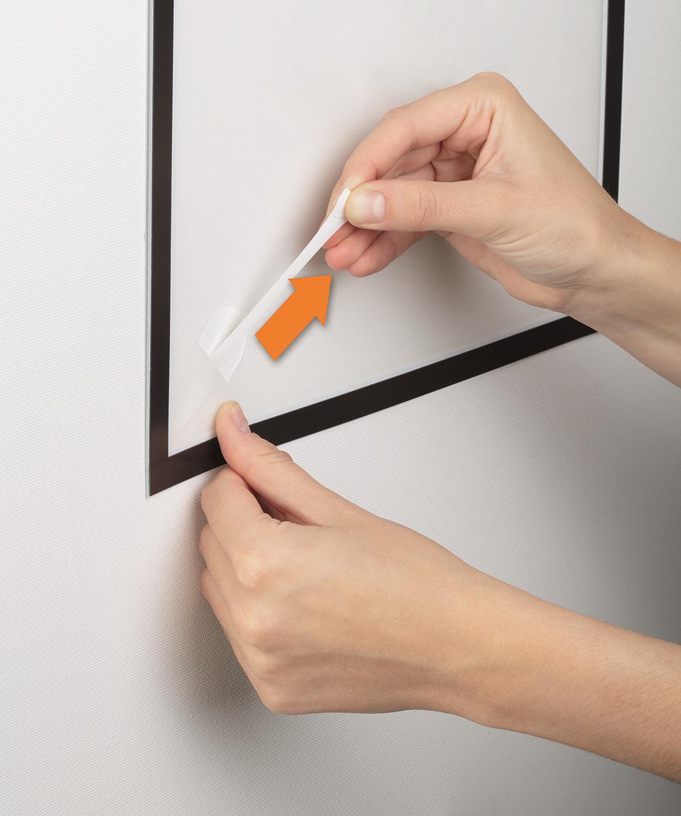 Person som applicerar svart Duraframe-väggpapper på en vägg med hjälp av en spatel