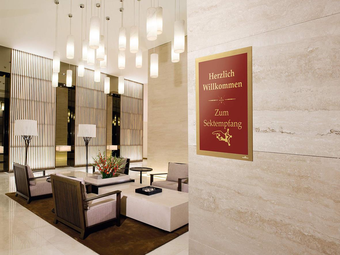 Informat Duraframe självhäftande guldfärgad A4 i en elegant hotellobby med sittgrupp och konst på väggen