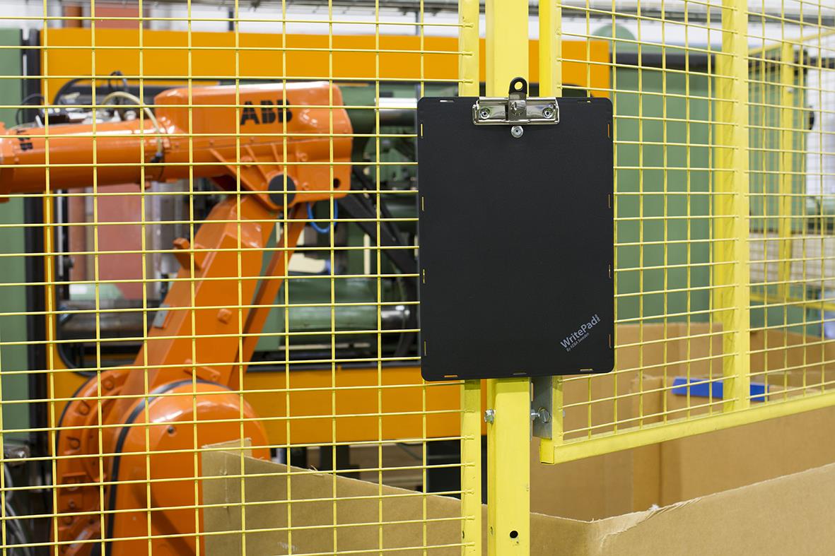 Svart magnetisk skrivplatta från Keba fäst vid galler i industriell miljö