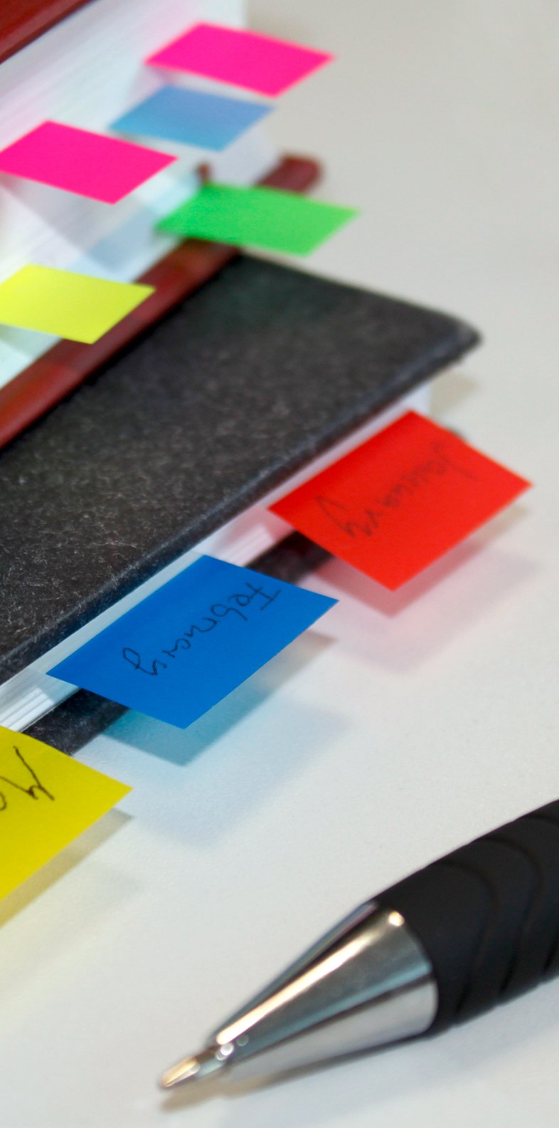 Färgglada märkflikar i olika färger på en bok, används för att markera och organisera sidor