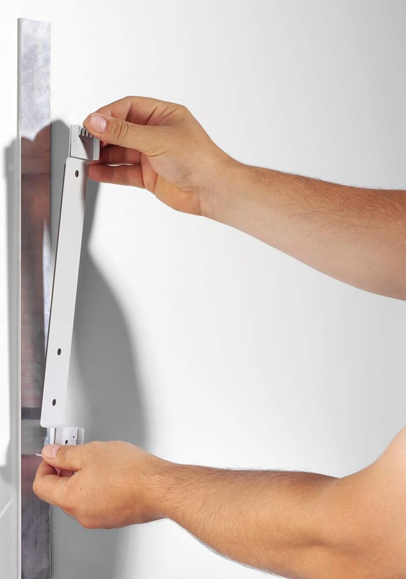 Person monterar Väggställ Durable Vario Magnet 5 paneler svart A4 på vägg