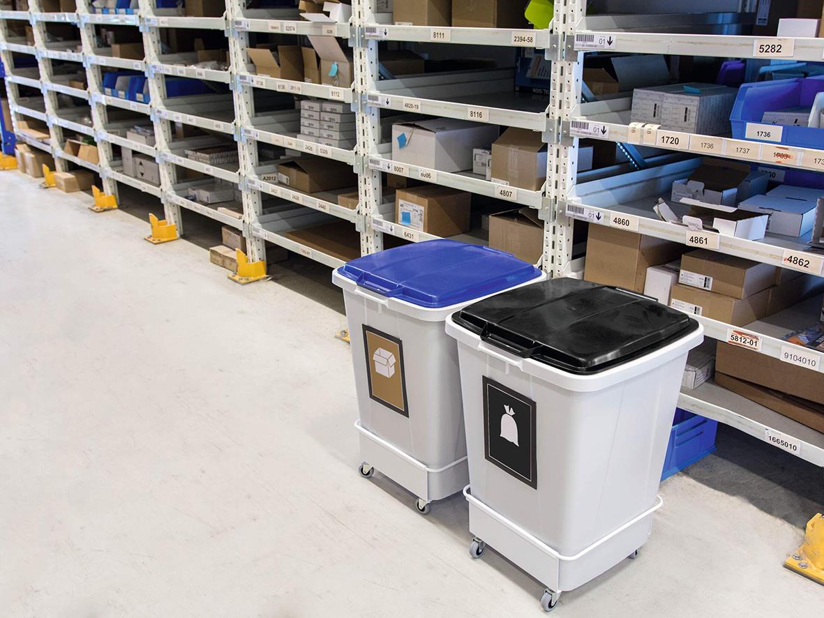Två återvinningskärl Durable Durabin 90L, grå och svart, placerade på butiksgolv framför hyllor