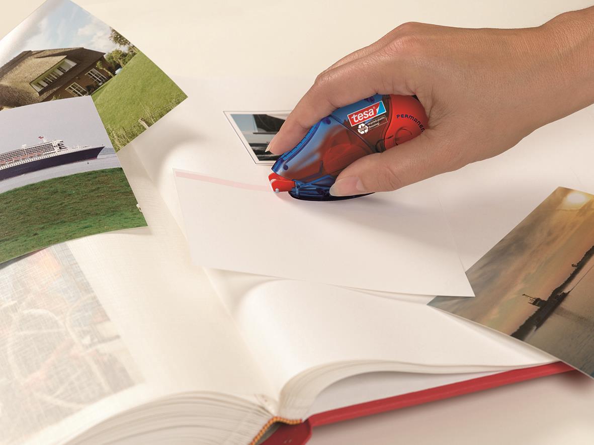 Hand som använder limroller Tesa Refill Permanent EcoLogo på papper med bilder