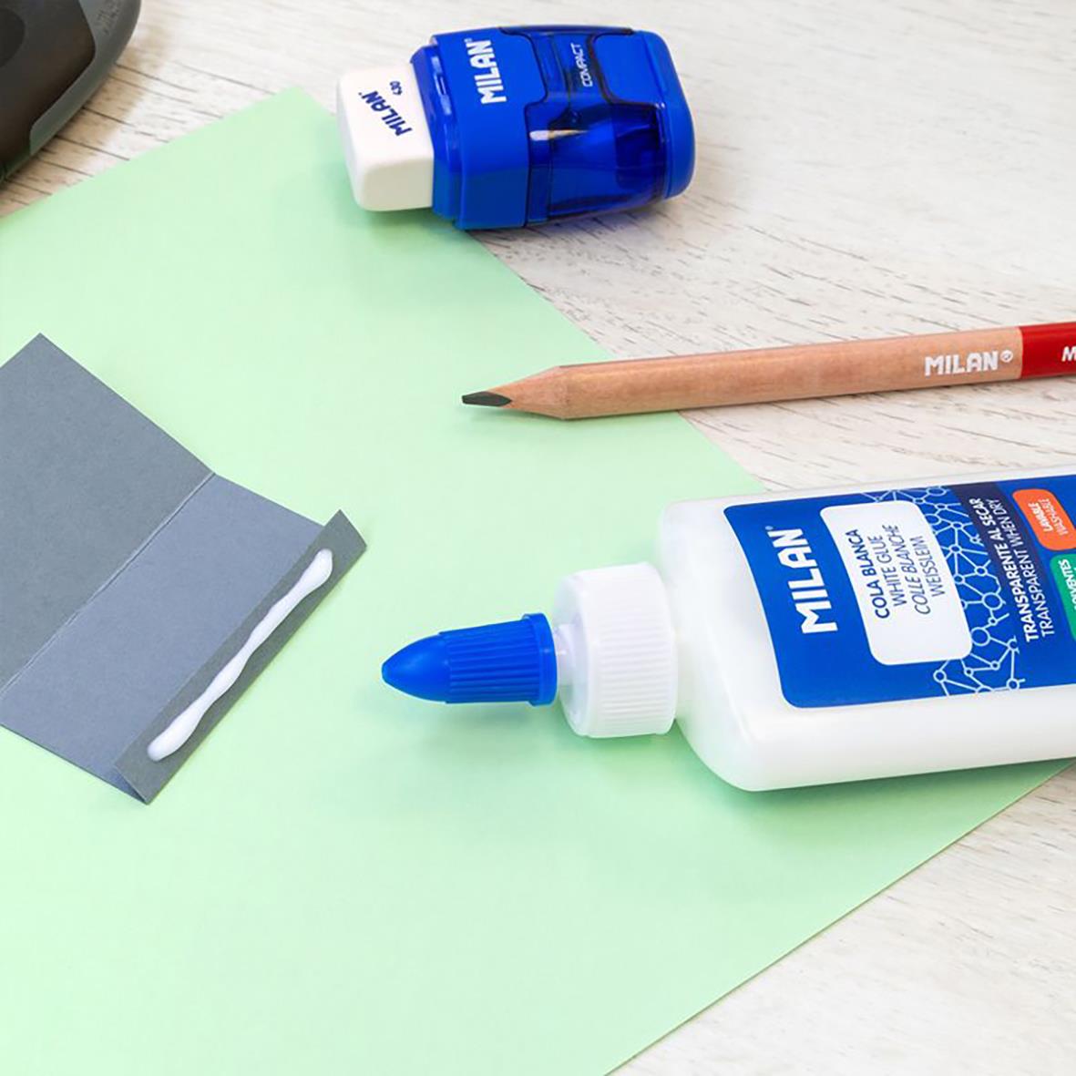 Skollim Milan flaska 100ml, blå och vit, med penna och papper på ett skrivbord