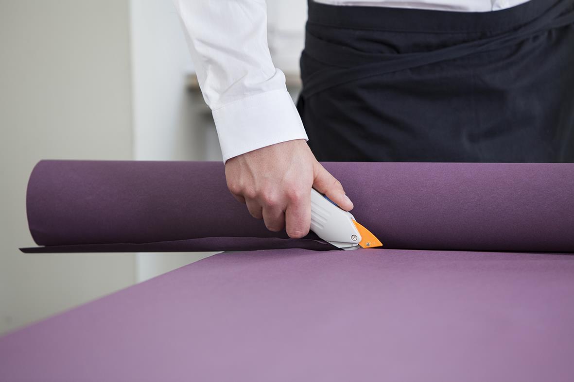 Person som använder batterisax Duni för att skära i dukrullar