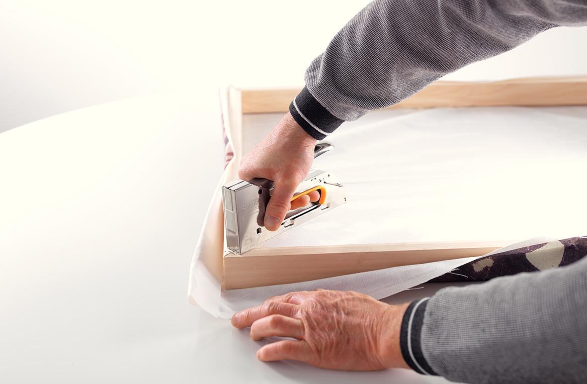 Person som använder en häftpistol Rapid R23 för att fästa papper eller material