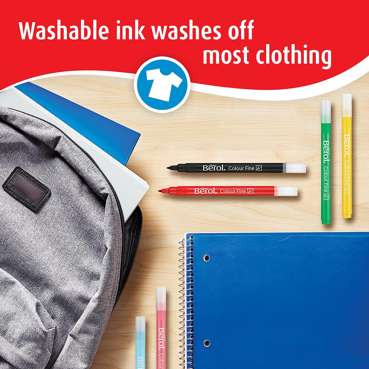 Tuschpenna Berol Fine Mixade Färger med tvättbar bläck, omgiven av andra pennor och en blå anteckningsbok på ett träbord