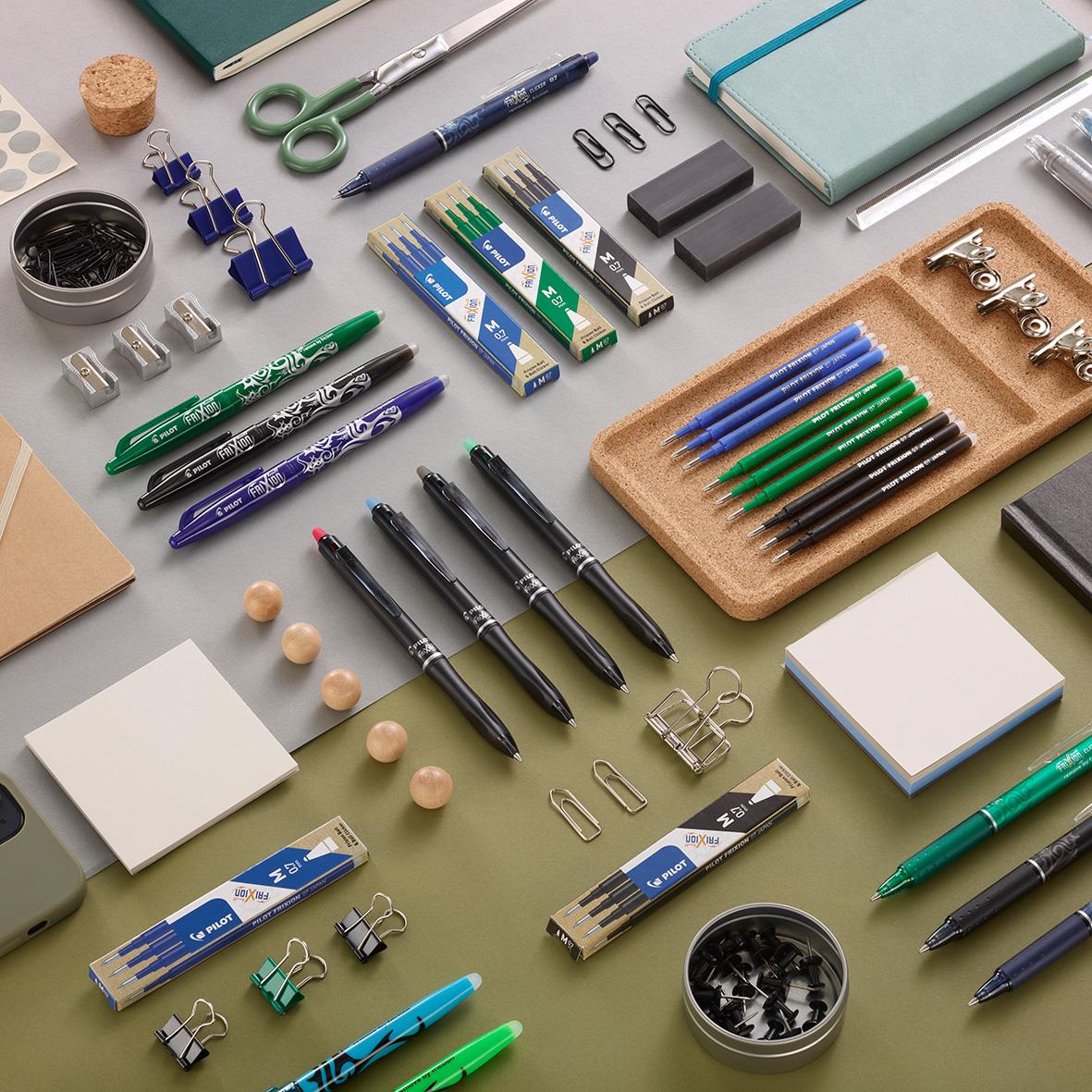 Kontorsmaterial med bläckpenna, klämmor, block, sudd och andra kontorsartiklar på ett bord