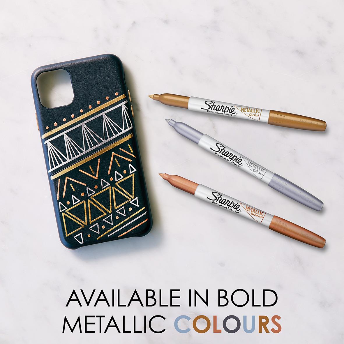 Märkpenna Sharpie Metallic Permanent 3 Färger Fine med mönstrad telefonfodral på vit marmorbakgrund