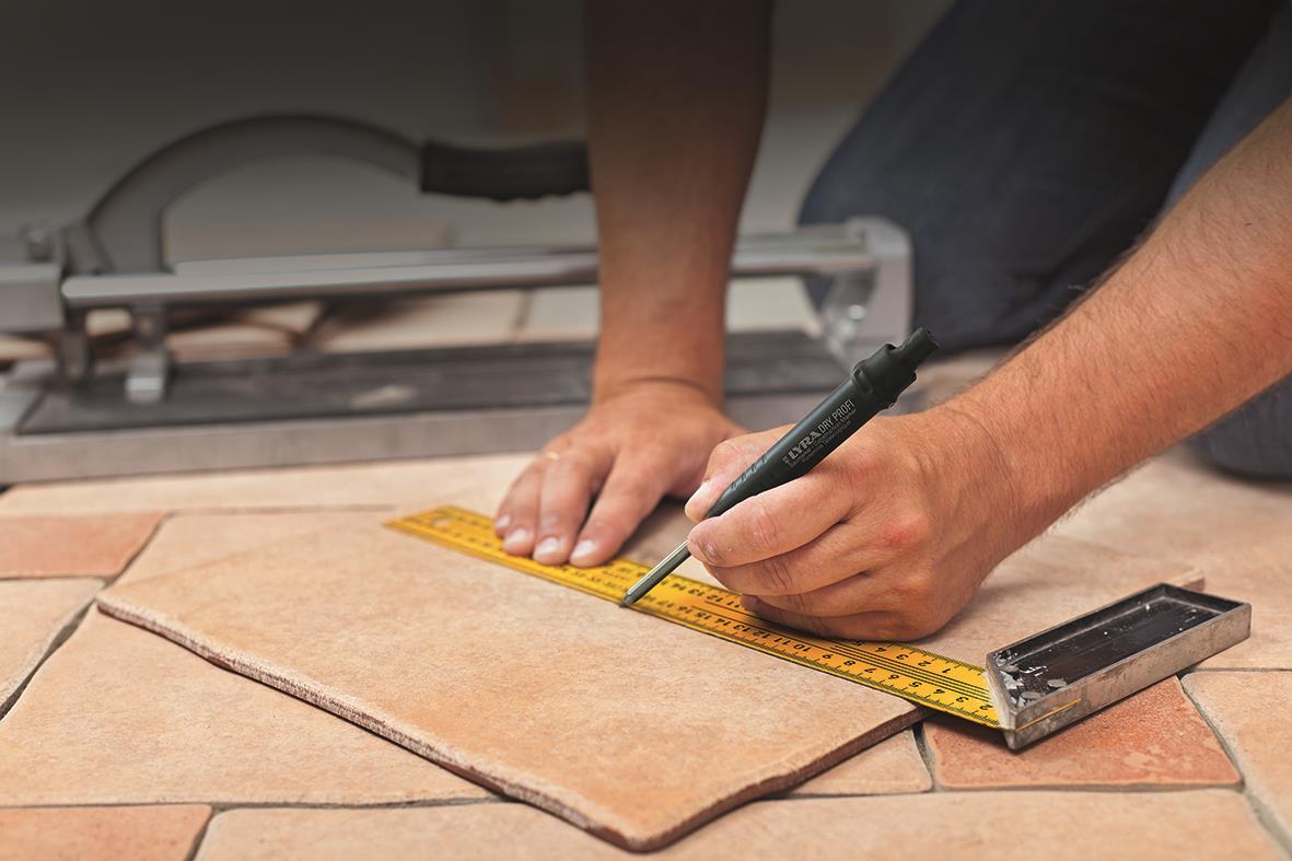 Person som använder Lyra Dry Profi 2,8 mm djuphålsmärkare för att markera på tegelplatta