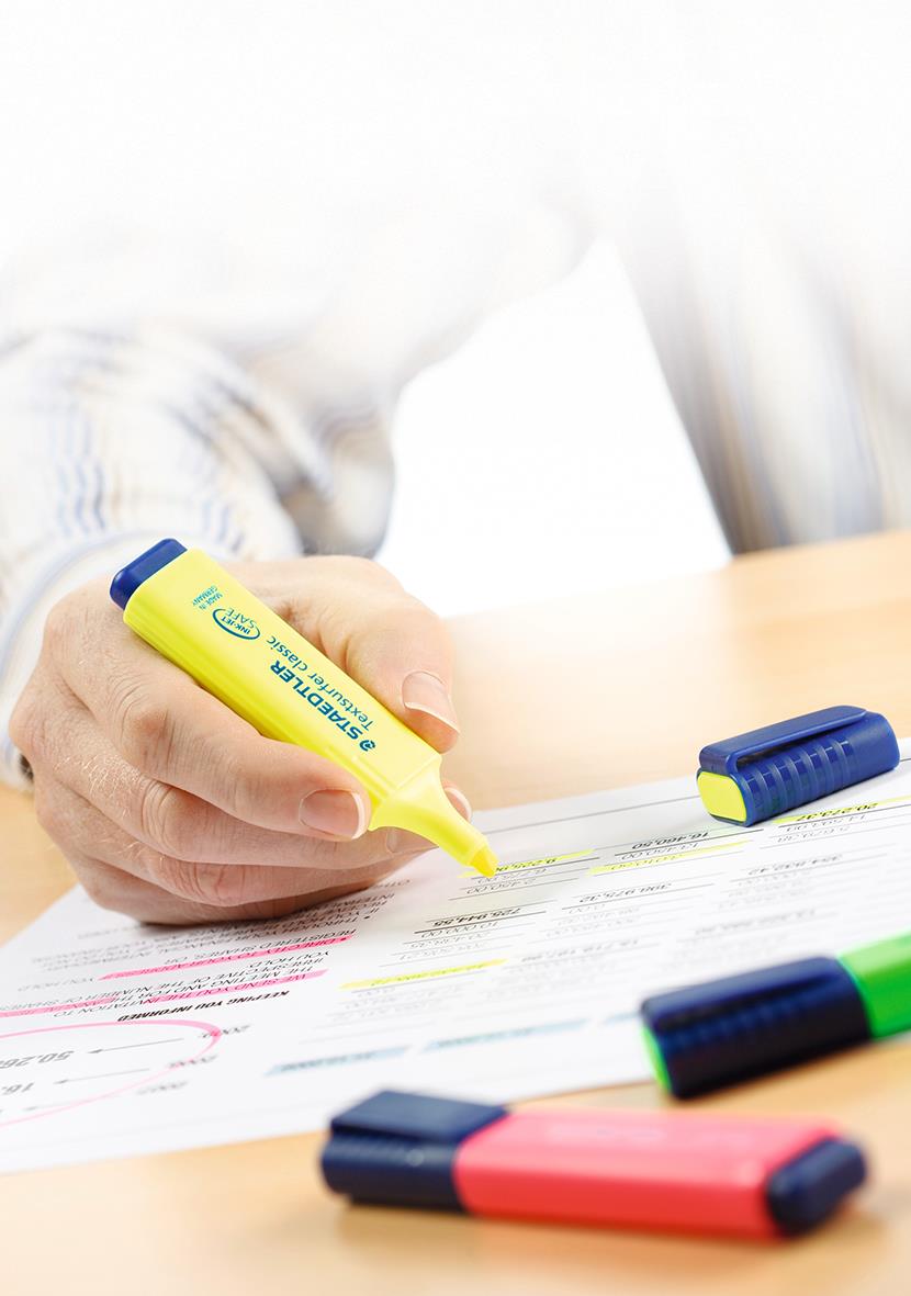 Person använder en gul överstrykningspenna på ett dokument med flera färgade överstrykningar