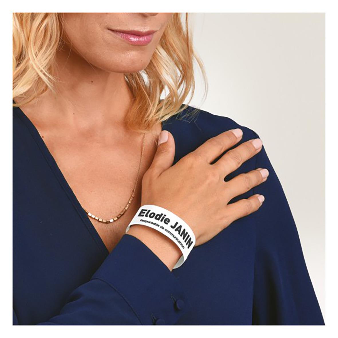 Vit handledsband med text Avery 265x18mm på en kvinnas handled
