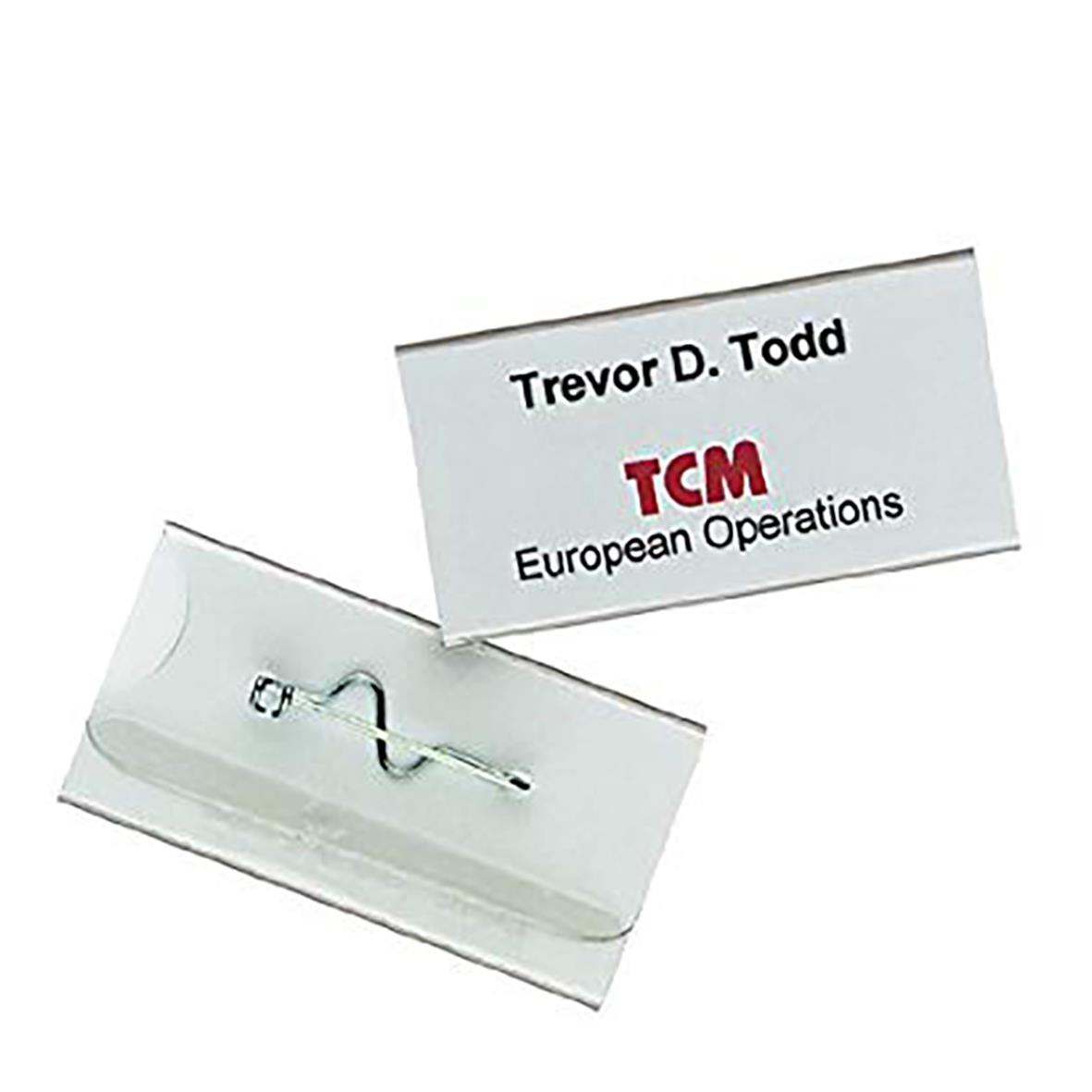 Namnskylt av hållbart material med nål, storlek 75x40mm, visar namn Trevor D. Todd och organisationen TCM European Operations