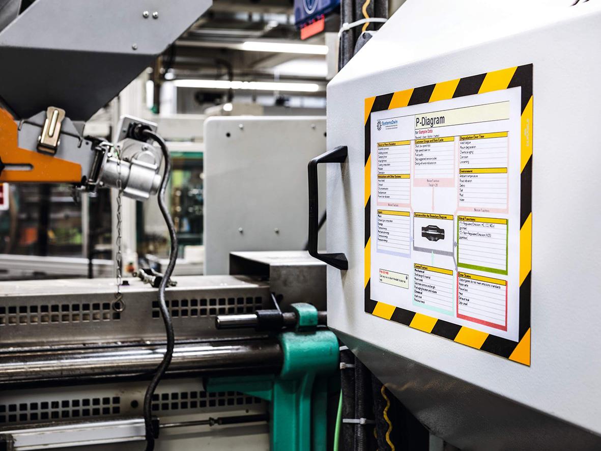 Duraframe Mag säkerhetsram i gul/svart för A4 papper monterad på maskin i industriell miljö