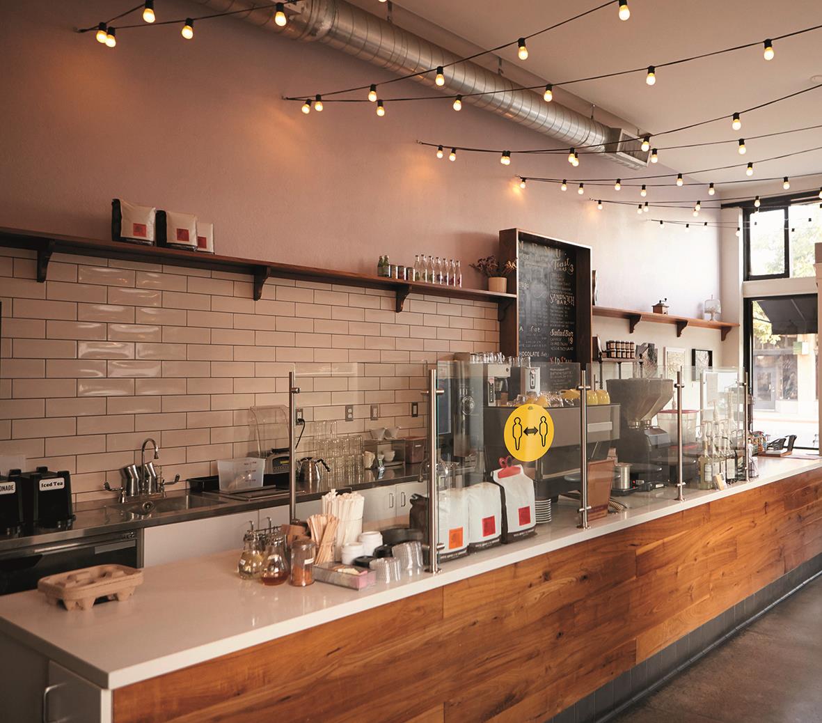 Etikett Avery Corona Indication gul Ø 20cm i ett café eller bar med barbord och belysning