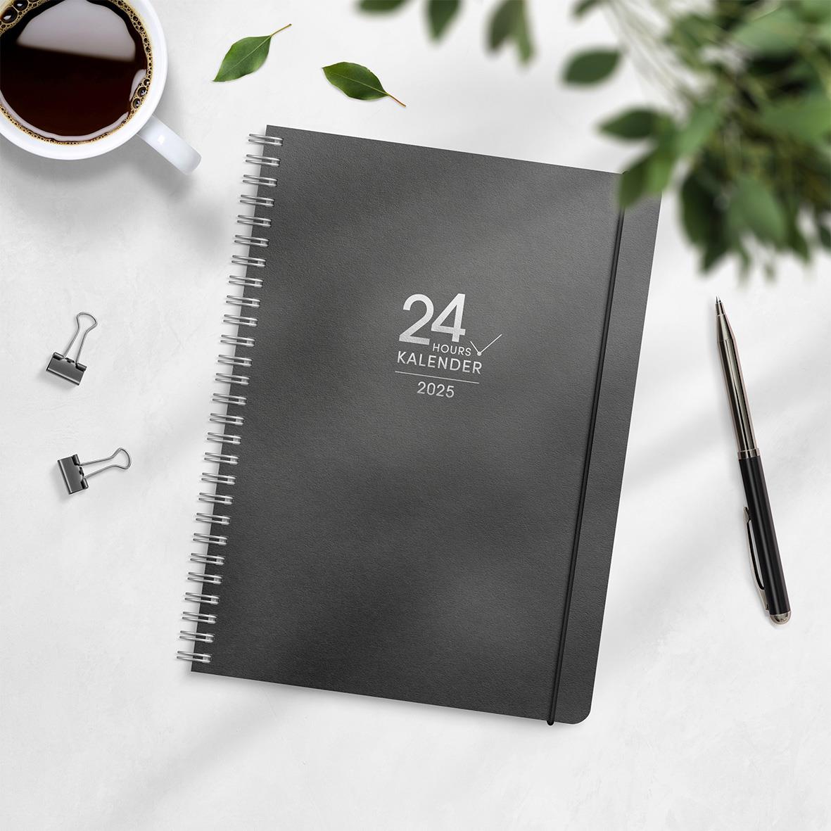 A5 24-timmars kalender för 2026 med spiralrygg, omgiven av en kopp kaffe, bläckpenna och klämmor på ett vitt bord