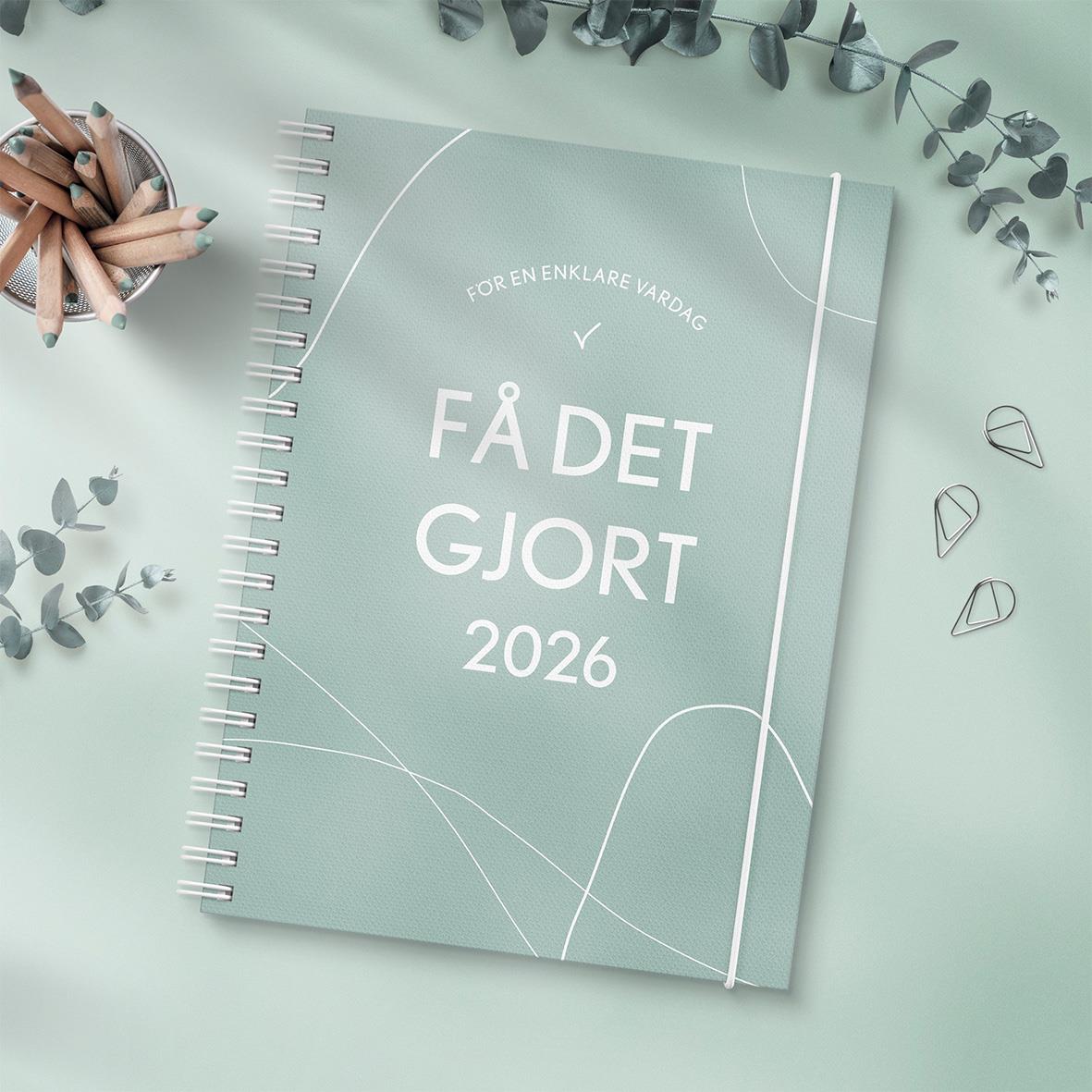 Grön A5 almanacka för 2026 med titeln Få Det Gjort, omgiven av bläckpennor och växtdekorationer