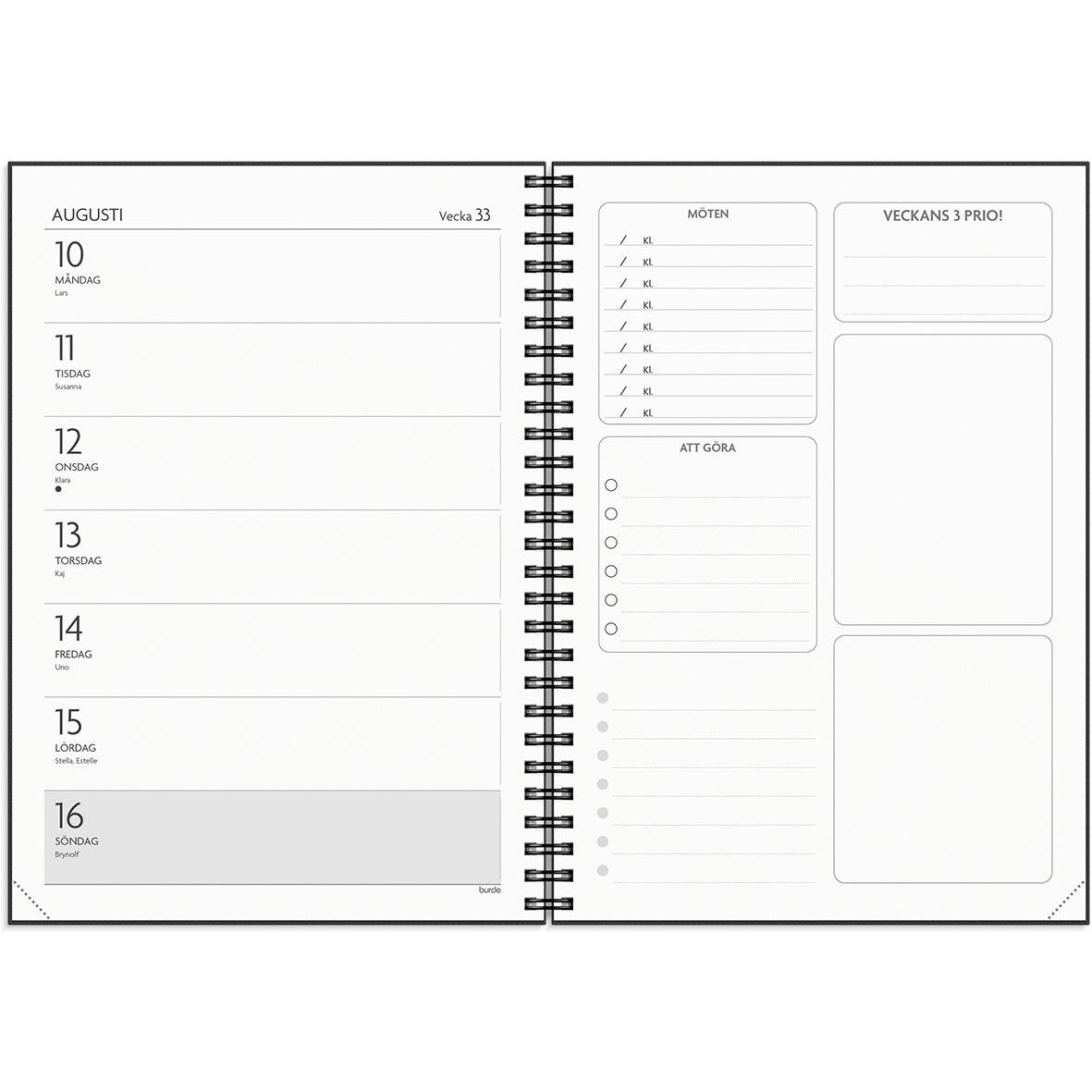 Svart almanacka med textet FÅ DET GJORT 25/26 på omslaget, omgiven av pennor och kontorsmaterial