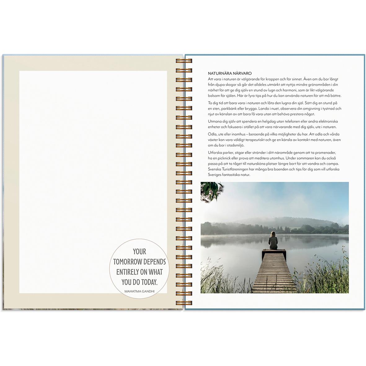 Öppen almanacka för 2026 med motiv av en person på en brygga vid en sjö och inspirerande citat på vänster sida
