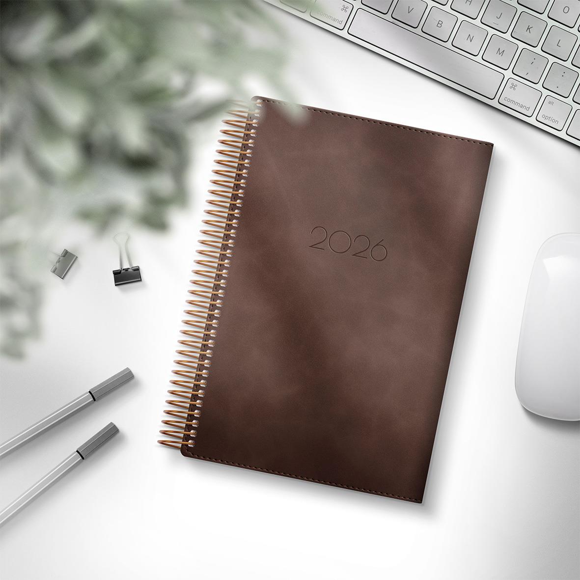 Brun Almanacka Burde 5578 Dagbok Twist 2026 135x205mm på skrivbord med tangentbord och pennor