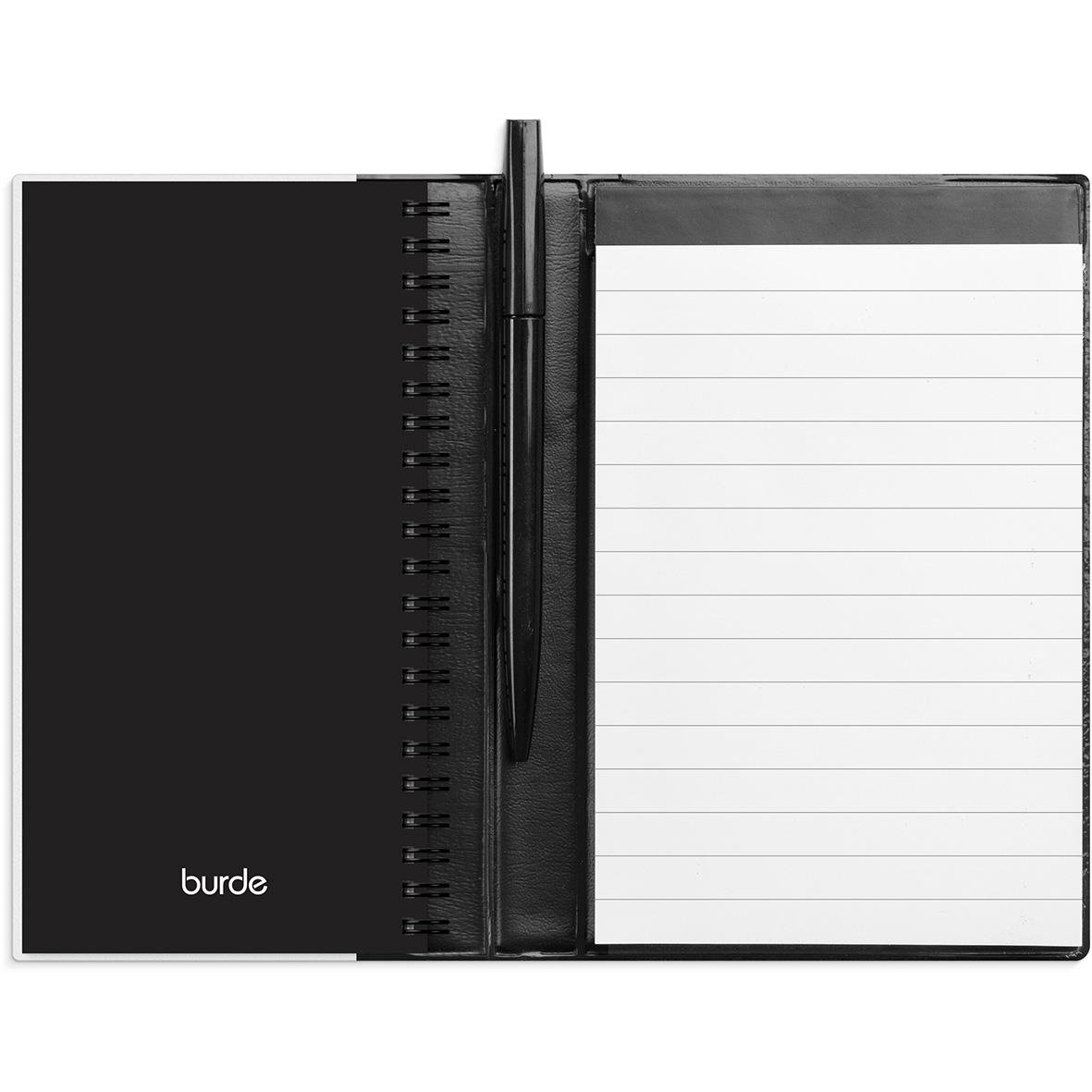 Svart almanacka med spiralrygg och penna, öppen för att visa linjerade sidor för anteckningar