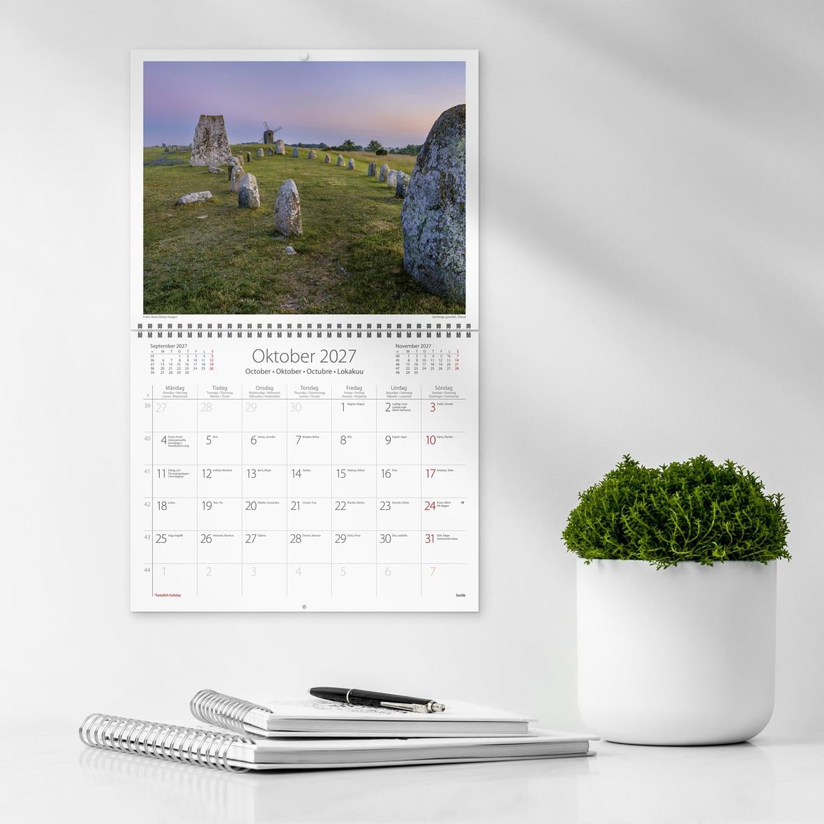 Väggkalender för oktober 2026 med landskapsbild och kuvert