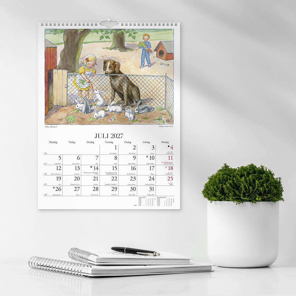 Väggkalender för maj 2026 med Elsa Beskows illustration av barn vid ett halmtak i en skog