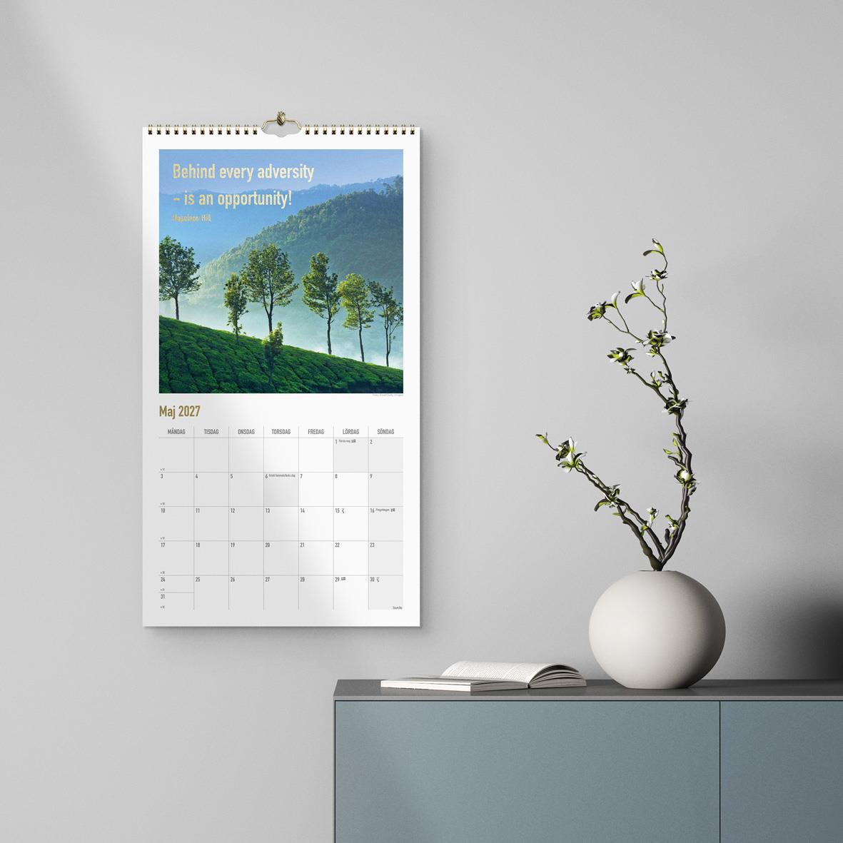 Väggkalender för 2026 med bild av sjö och berg, samt inspirerande citat om att vilja och göra