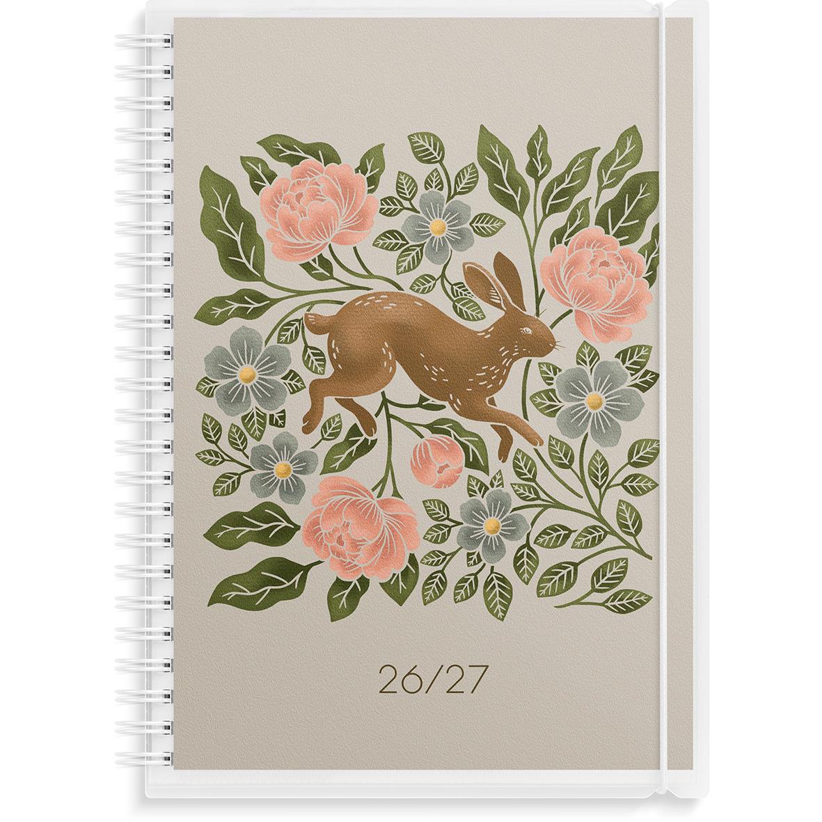 Svart almanacka med vita siffror 25 och 26 på framsidan, spiralbindning på vänster sida