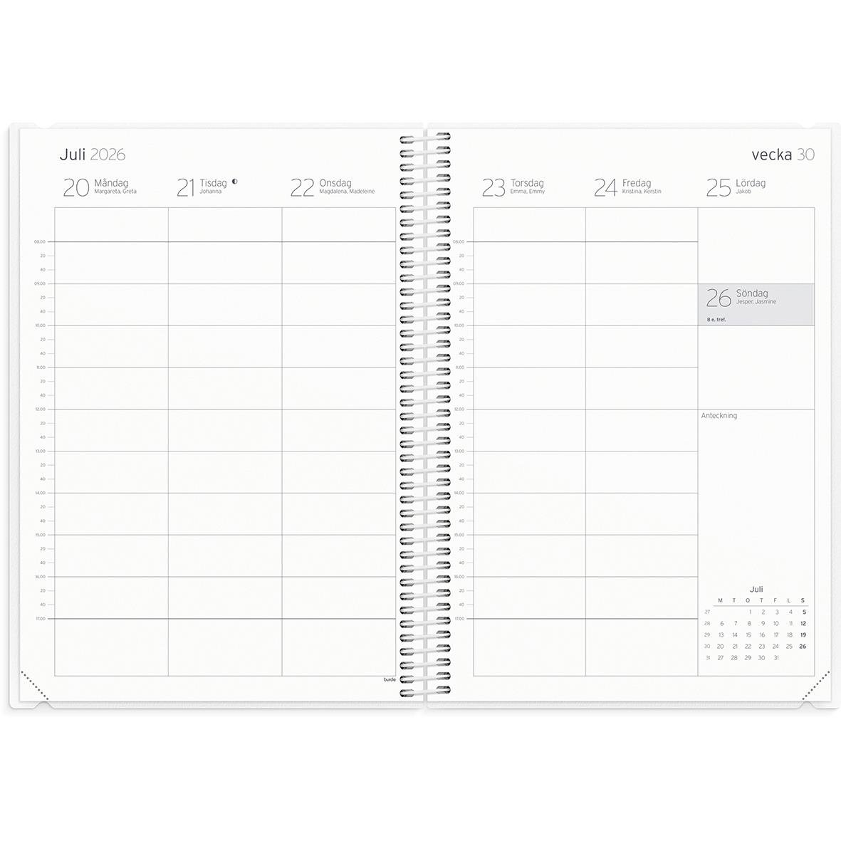 Stort lärarekalender för 2025/2026 med spiralbindning och blå omslag, omgiven av växt, tangentbord, penna, och mus på skrivbord