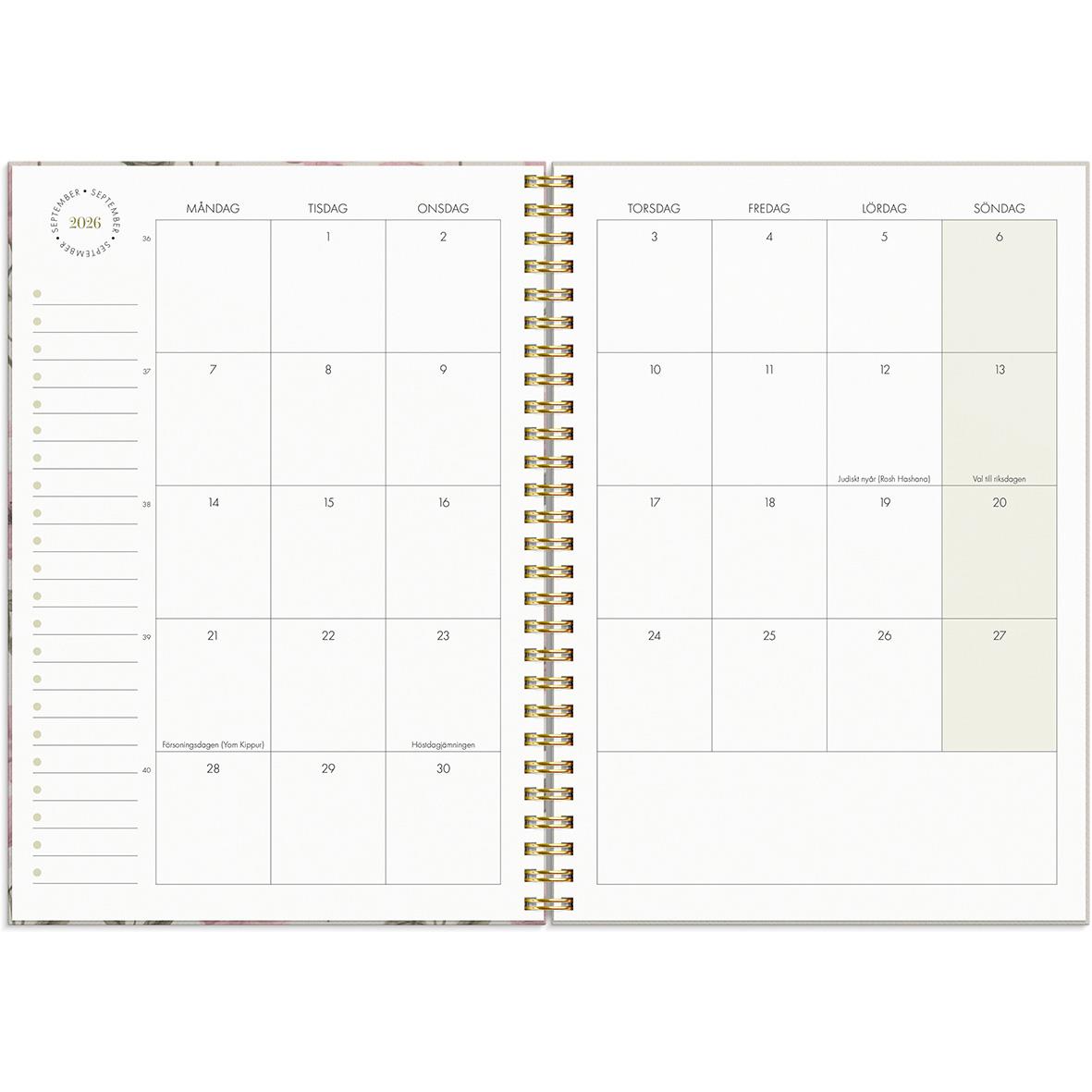 Öppen kalender för 2026 med veckoplanering i A5-format, guldfärgad spiralbindning och plats för anteckningar