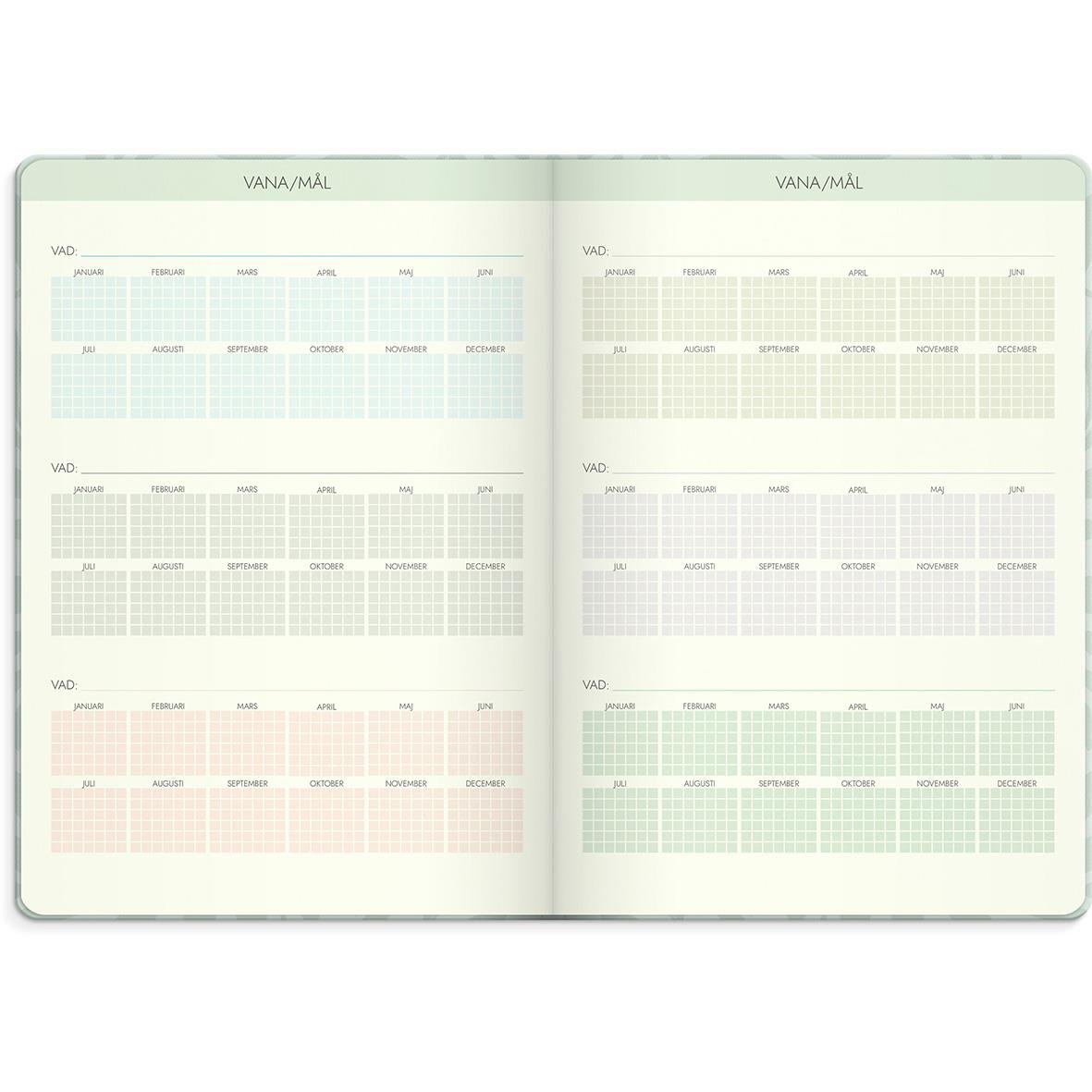 Öppnad almanacka för 2026 med plats för mål och planer, i grönt och rosa nyanser