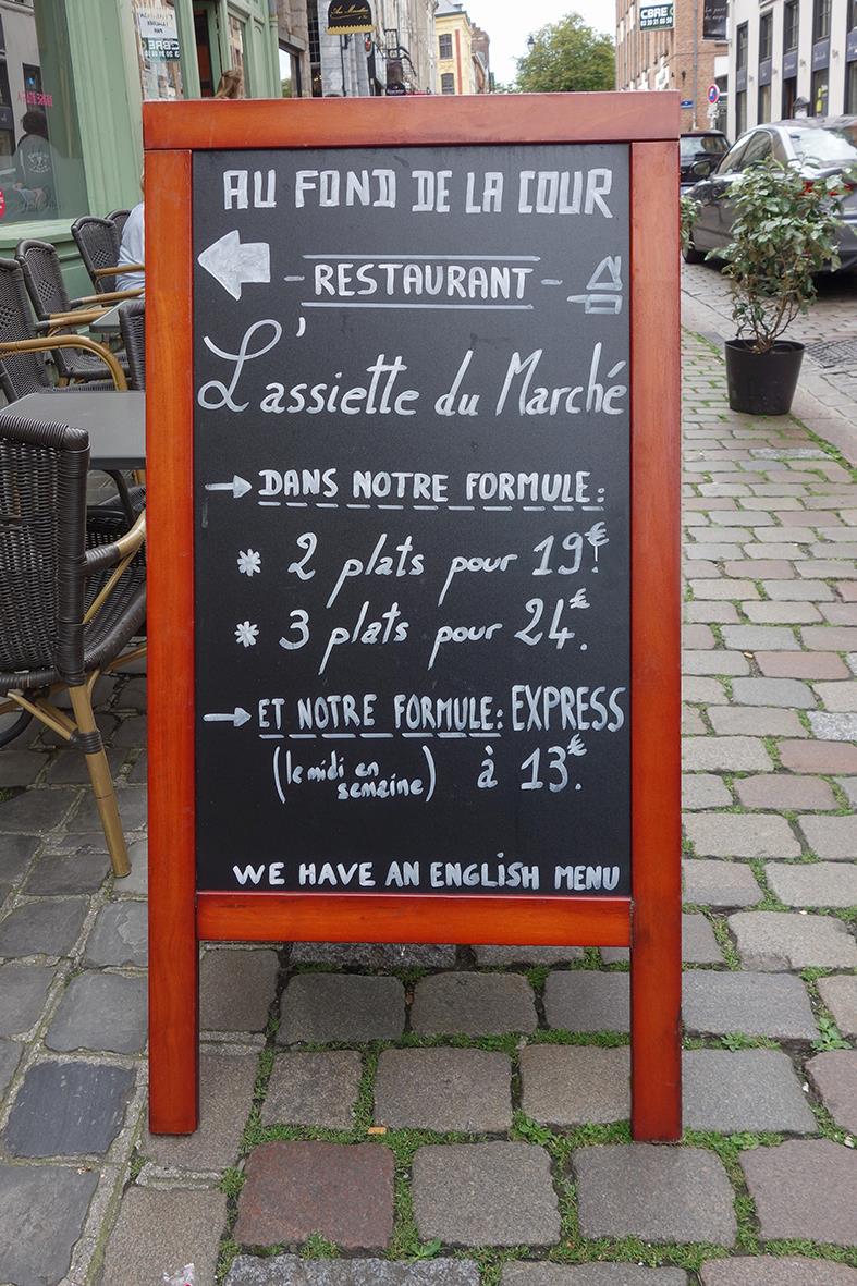 Gatuprydnadsskylt av mahogny med meny och erbjudanden för restaurang, text på franska och engelska