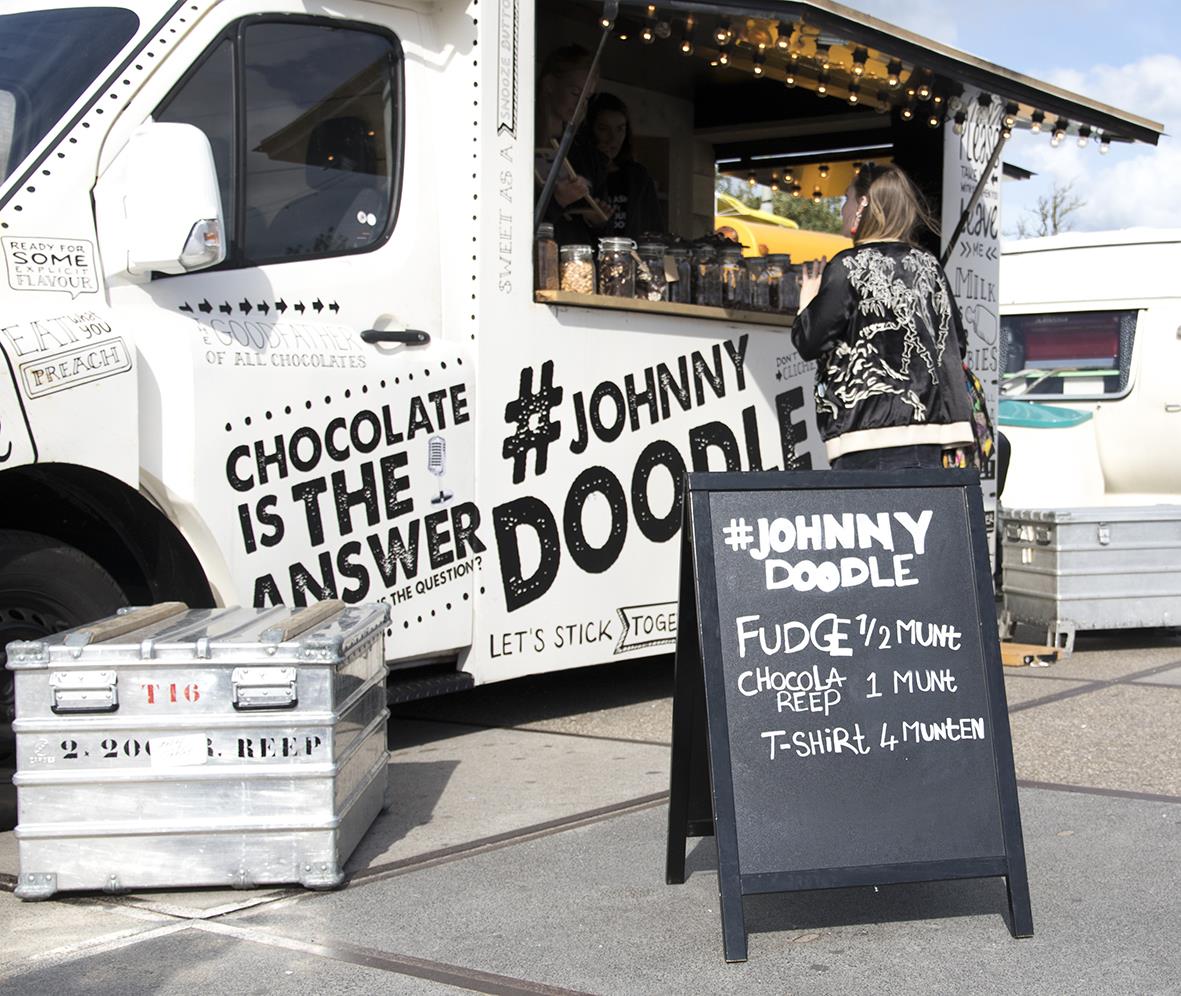 Gatuställ med foodtruck och skylt som annonserar Johnny Doodle choklad