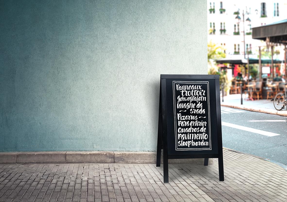 Gatuställ Securit Woody Furu svart 58x87cm med skrivyta placerad på trottoaren