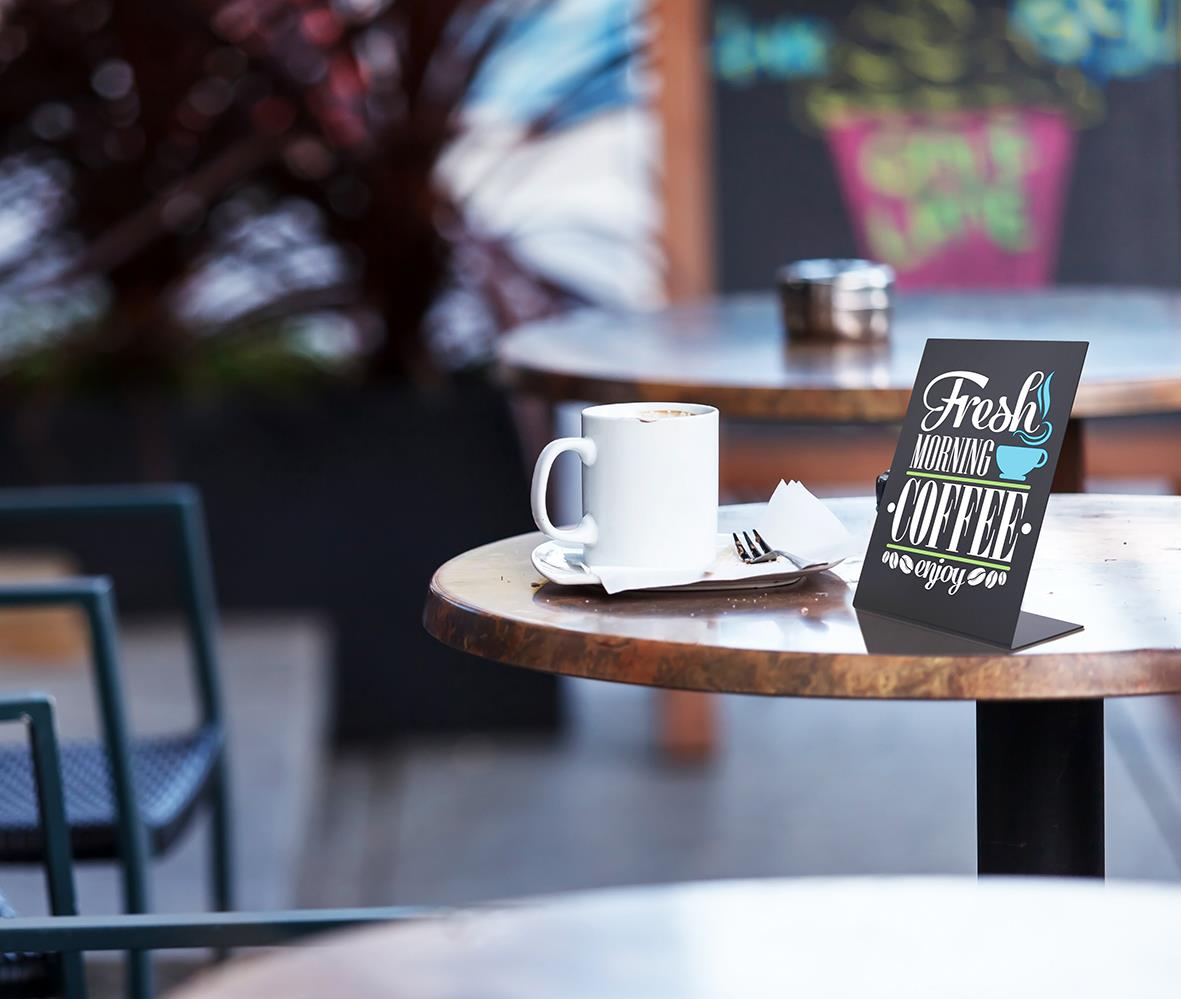 Svart akryl Griffeltavla Securit L-form på bord med kaffe och meny