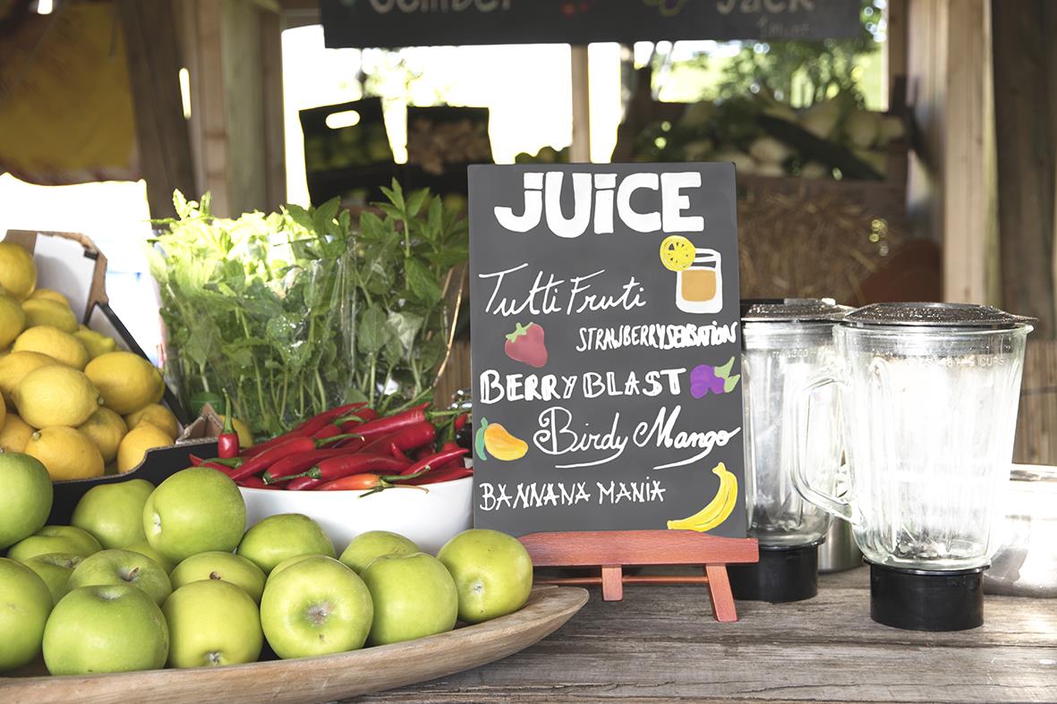 Griffeltavla med juice och frukt på ett bord, äpplen, chili, citroner och glas