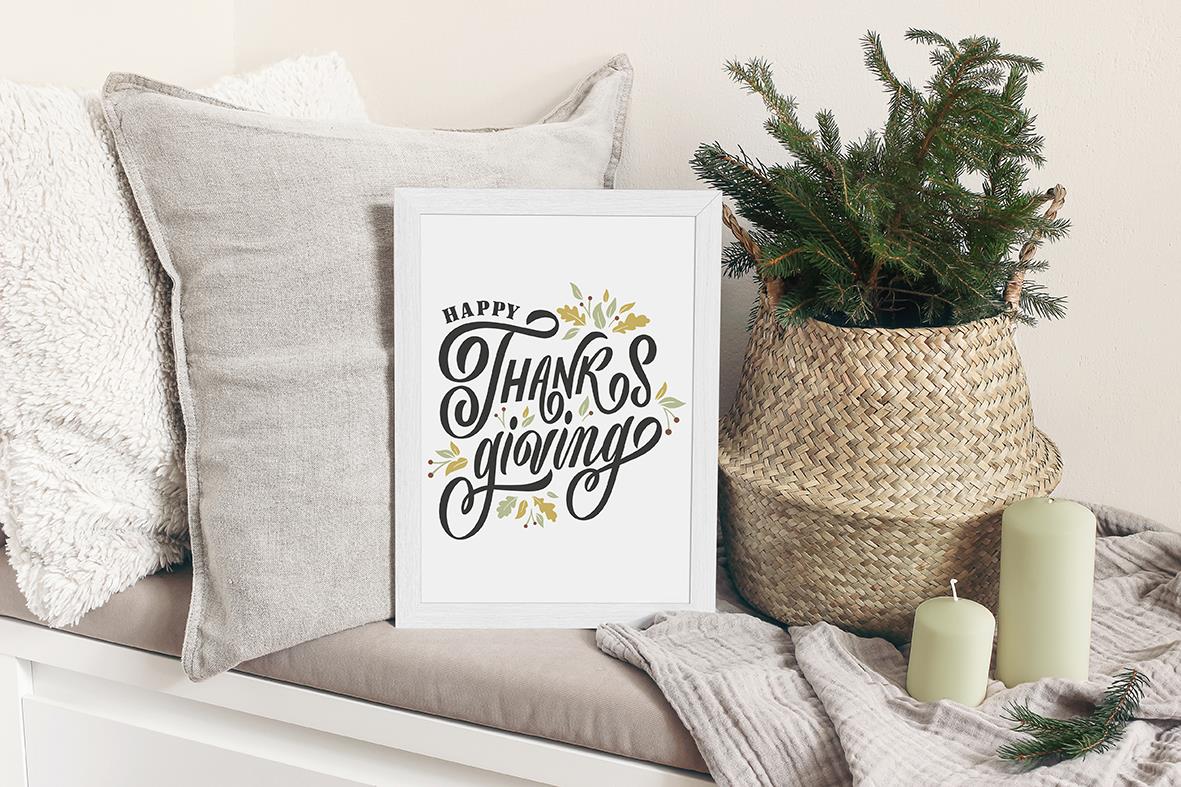 Vit griffeltavla Securit för vägg med texten Happy Thanks Giving, omgiven av kuddar, växt och ljus