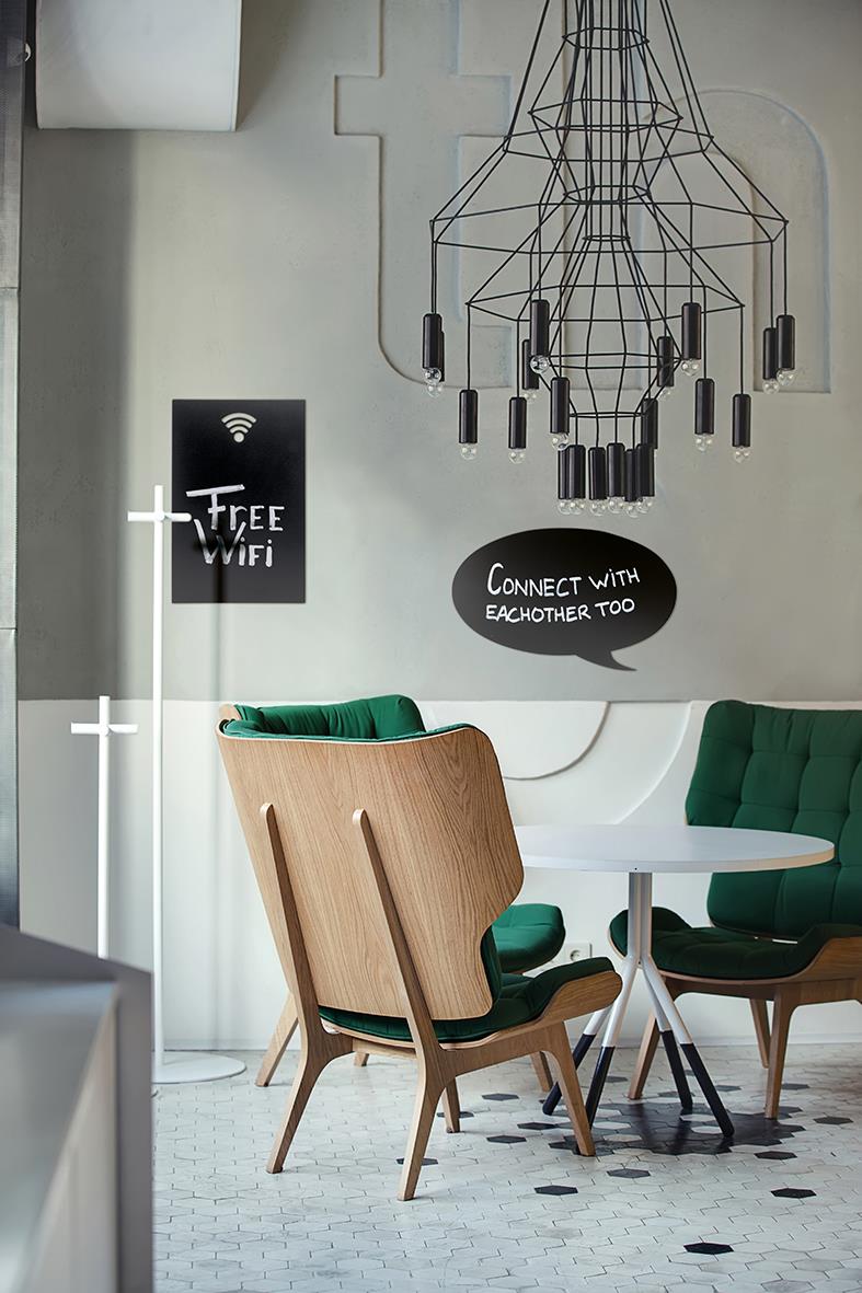 Griffeltavla med Wi-fi-symbol och text Connect with eachother too, i ett modernt café eller kontorsmiljö