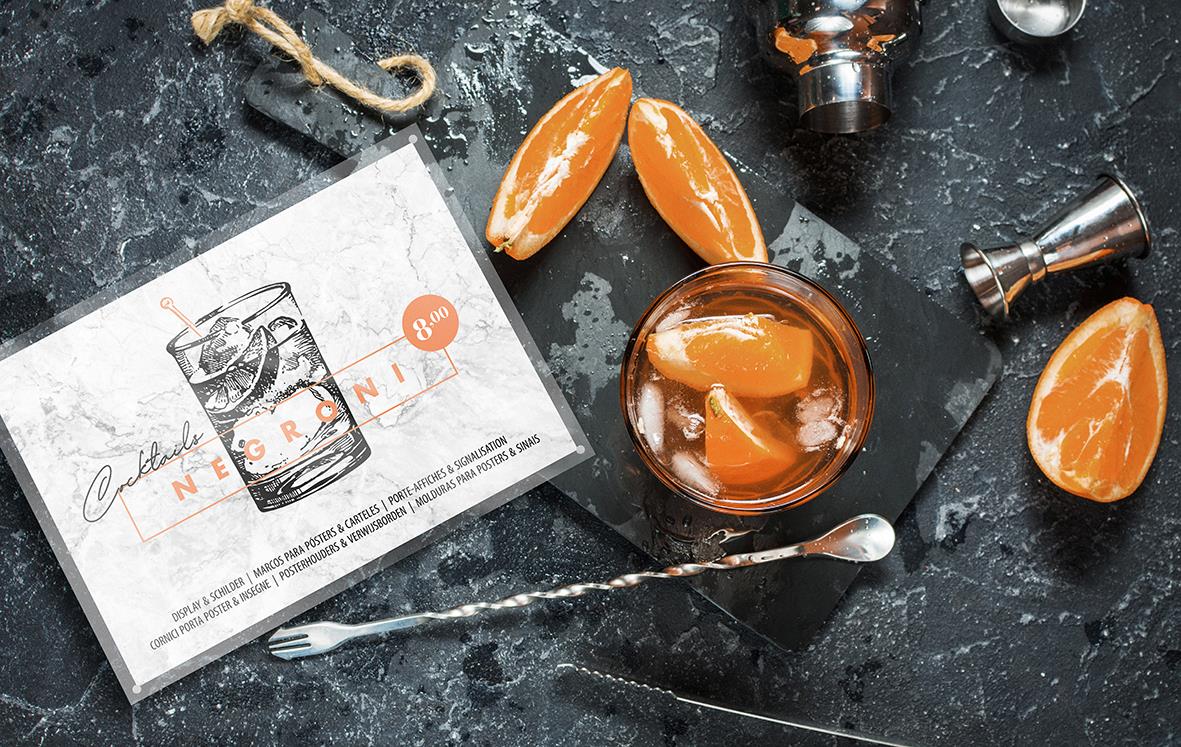 Förpackning med orangea skivor, ett glas med apelsinskivor, och andra matrelaterade föremål på en mörk yta