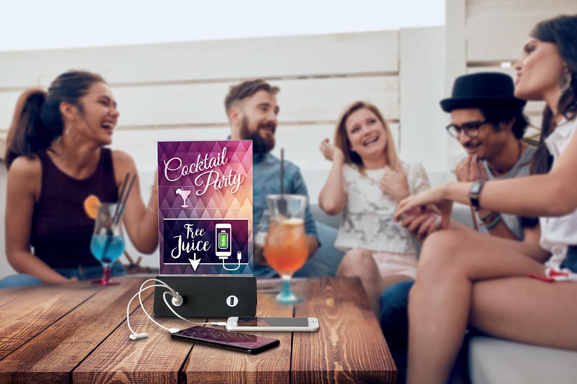 Grupp människor som har fest med drinkar och en powerbank på bordet